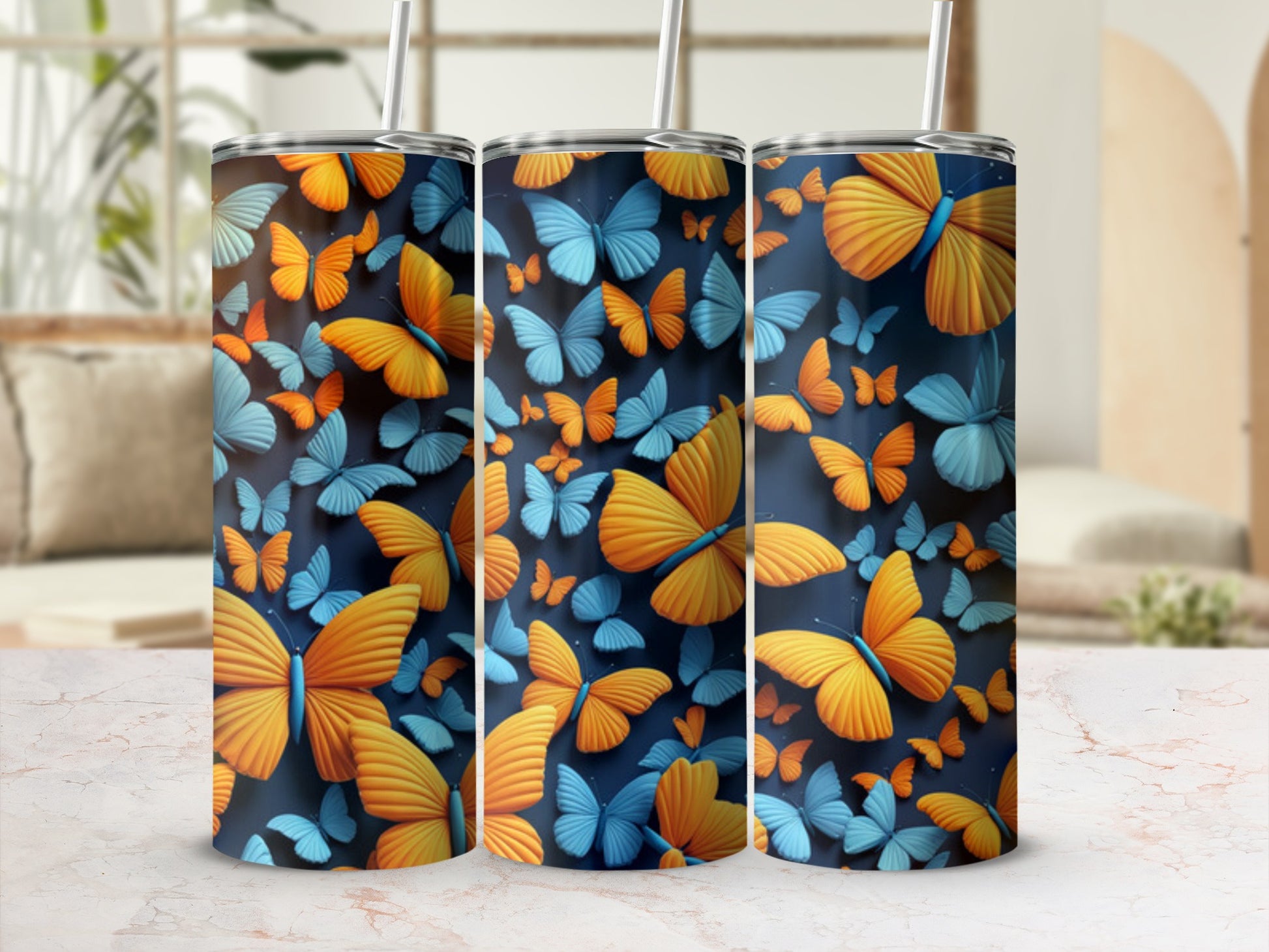 Three tumblers with an orange and blue butterfly pattern against a blurred background.