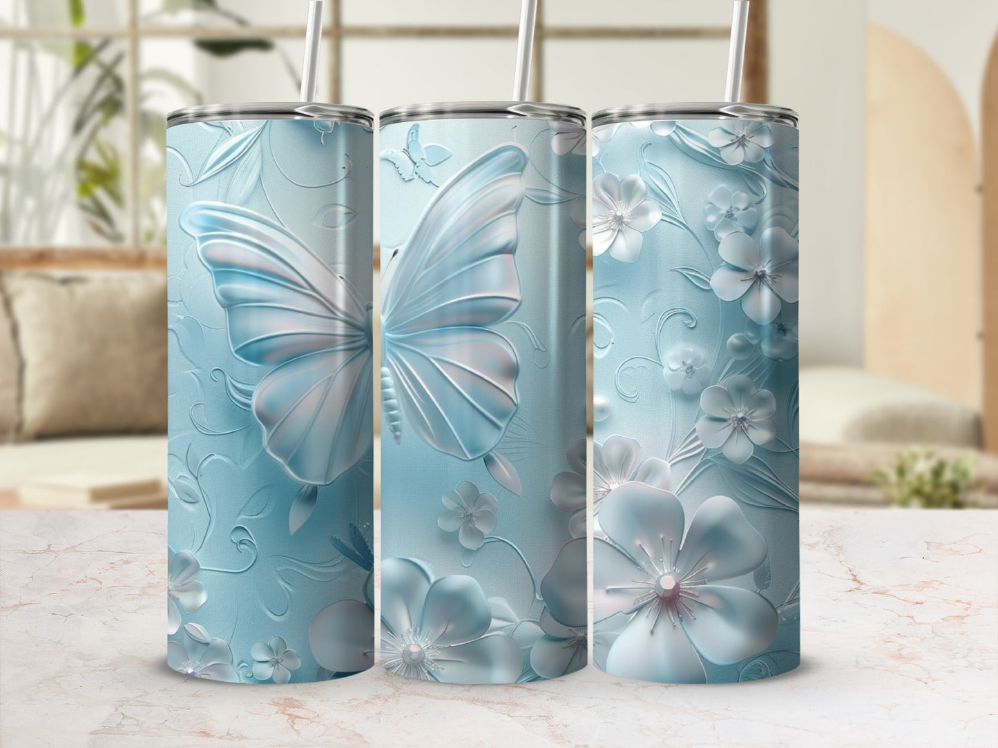 Three blue tumblers with embossed butterfly and floral designs.