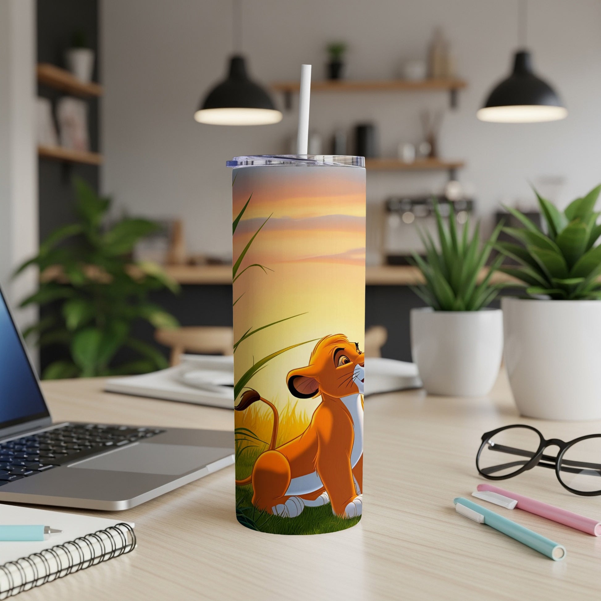 Simba from The Lion King sits on a desk next to a laptop and pens.
