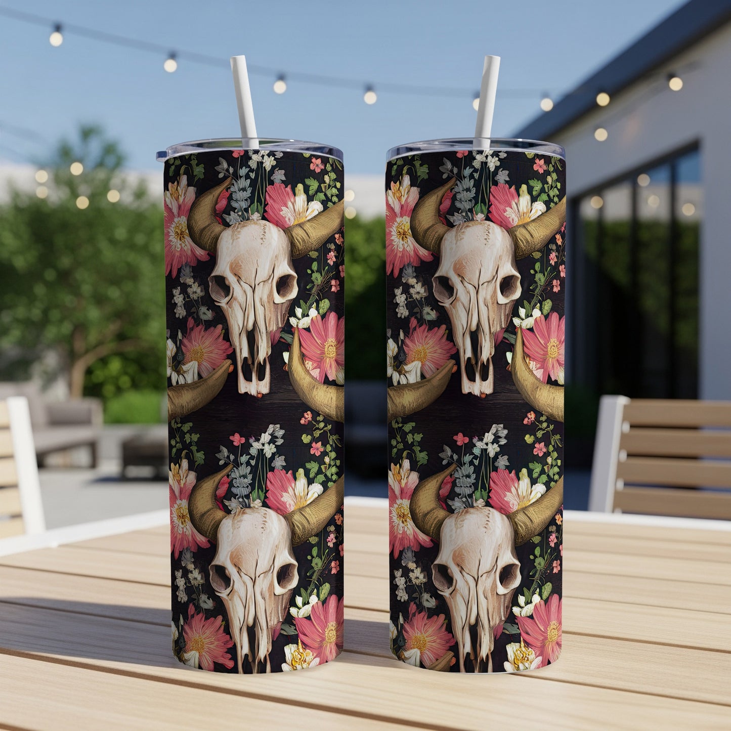 Steer skull and floral pattern on two tumblers on a wooden table.