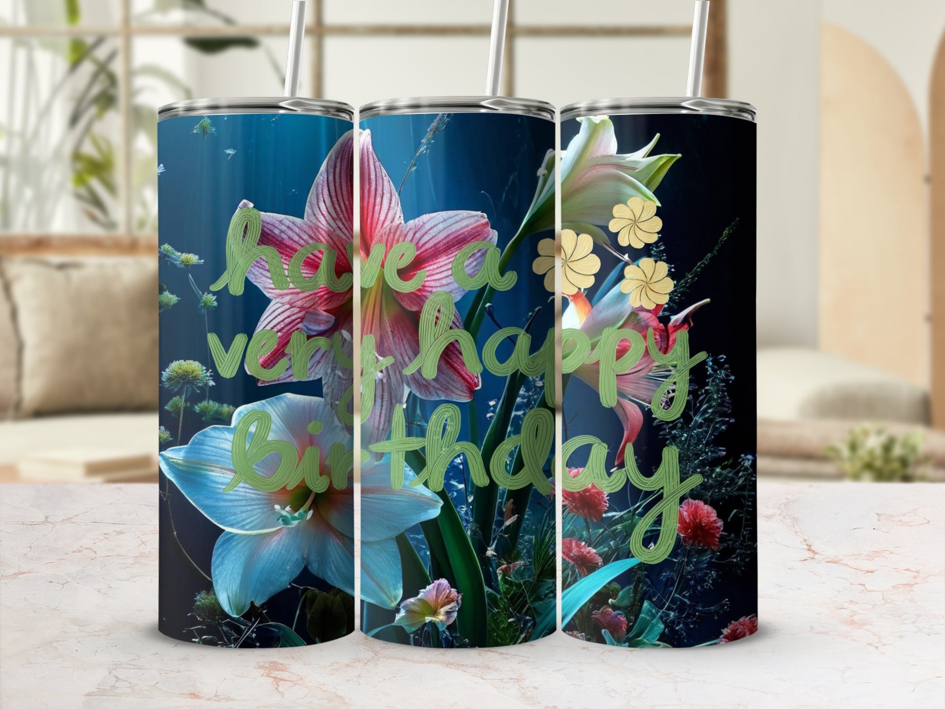 Three tumblers with a floral "Happy Birthday" design on a marble surface.