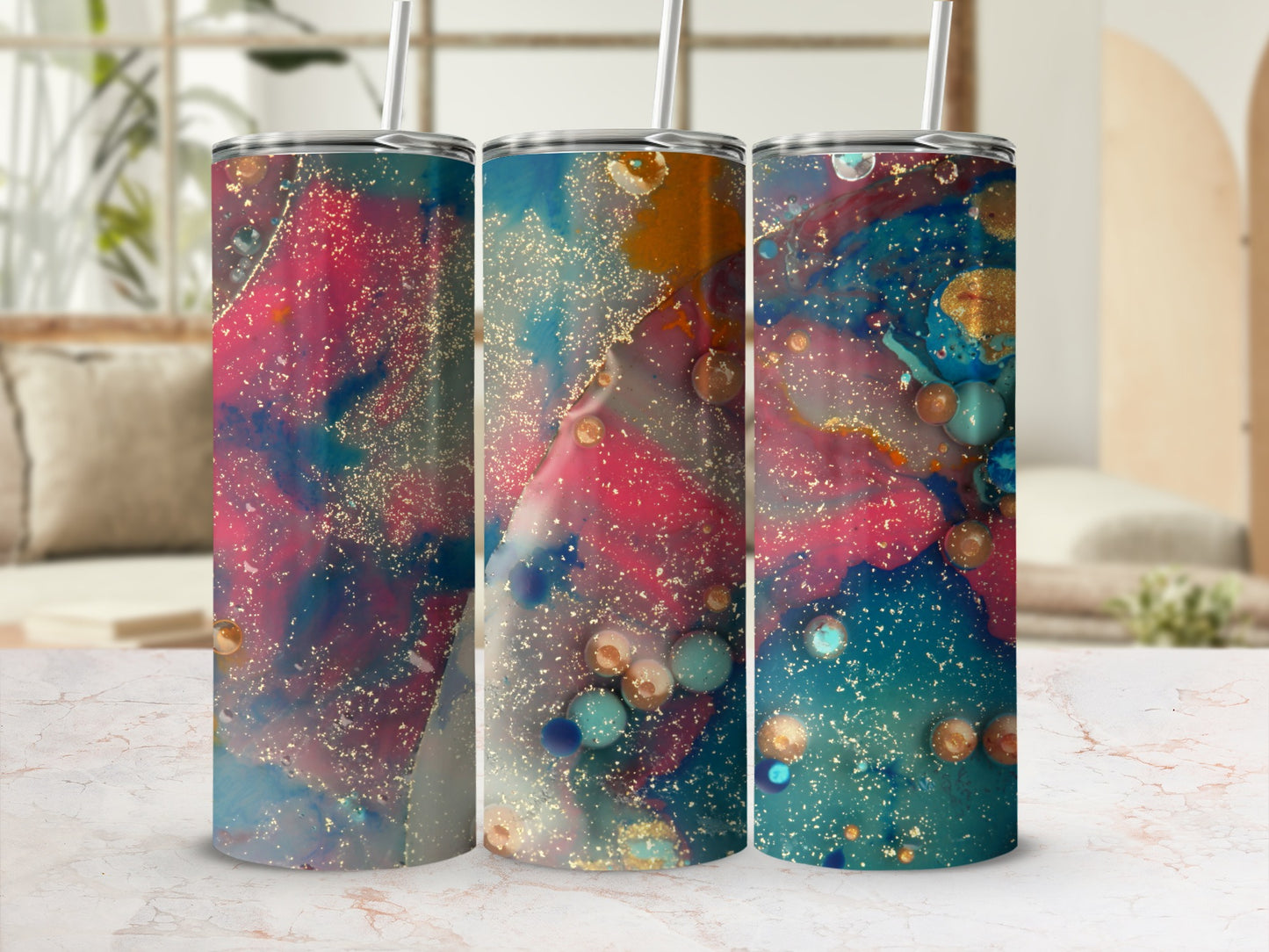 Three tumblers with colorful abstract splatter art, gold flecks, and straws.