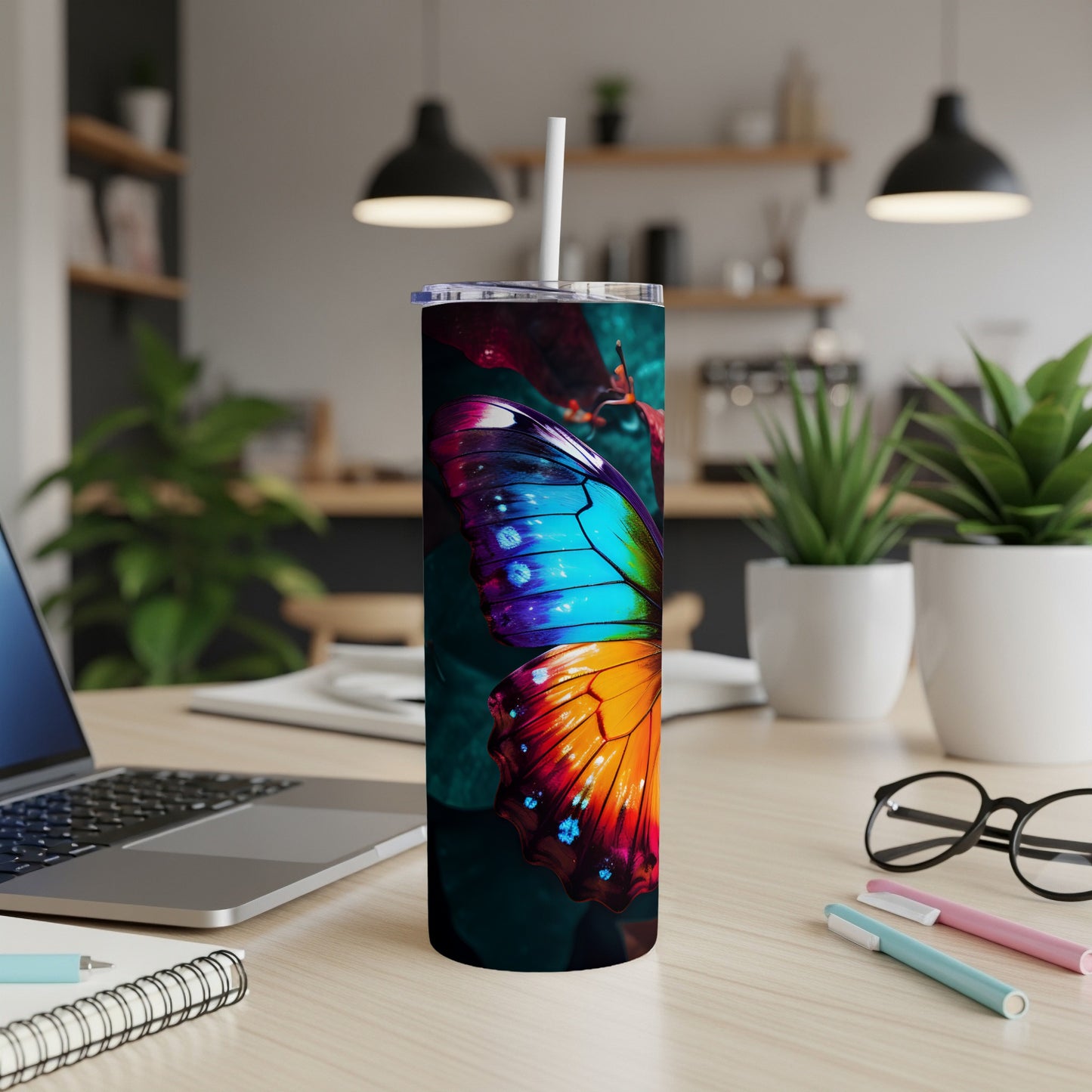 Colorful butterfly design on a white tumbler with a straw, on a desk.