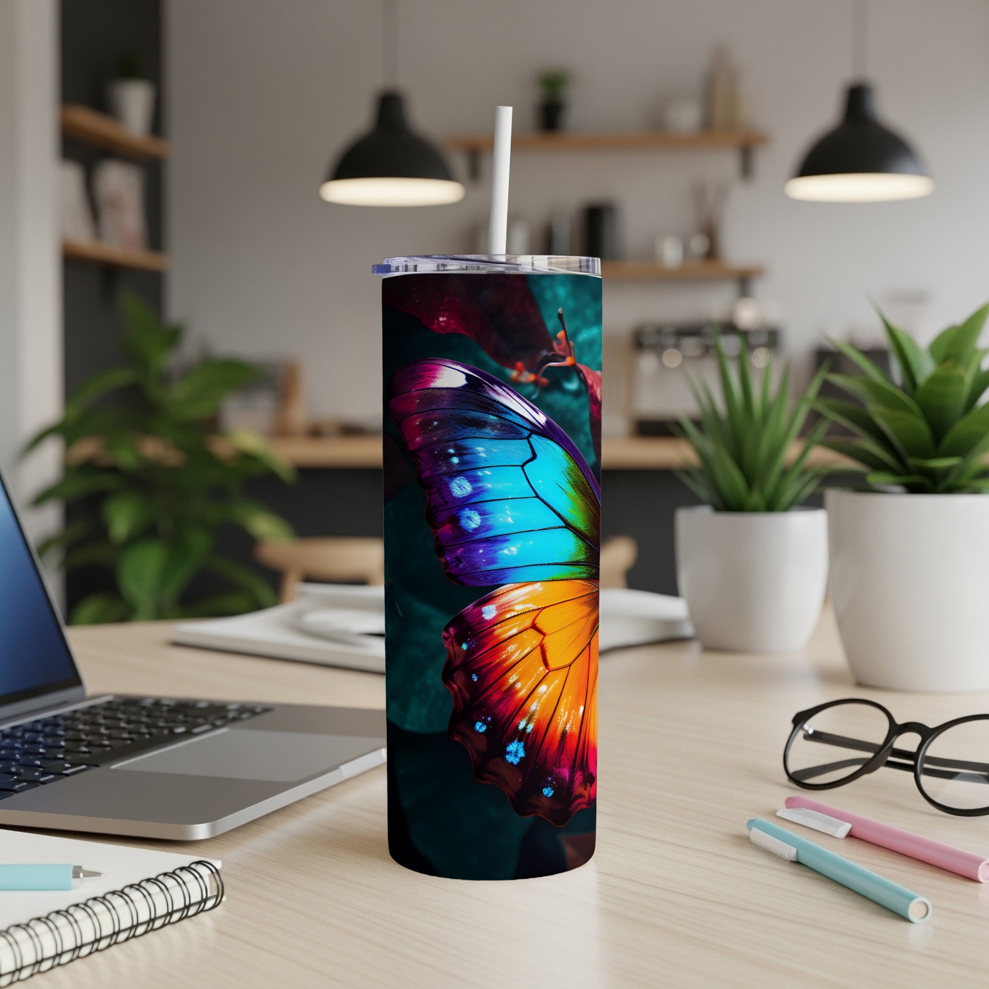 Colorful butterfly design on a white tumbler with a straw, on a desk.