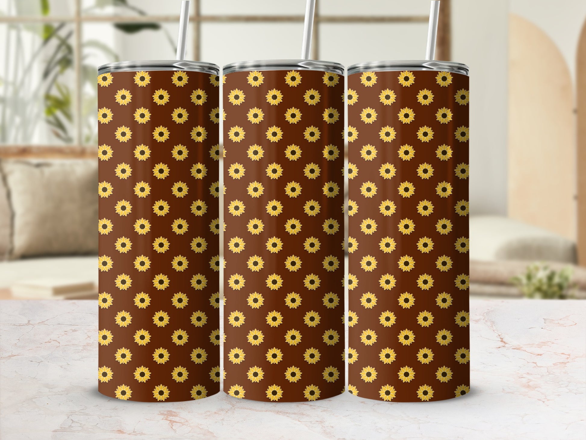 Three tumblers with a repeating sunflower pattern and straw.