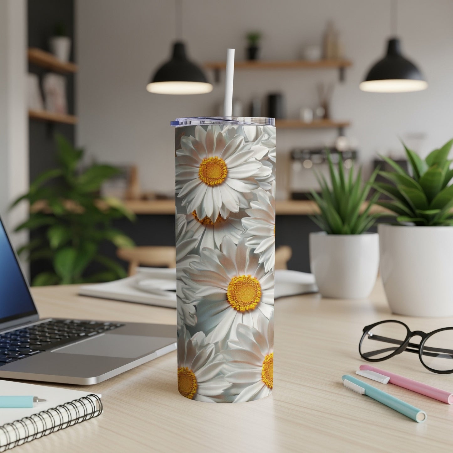 White daisies cover a white stainless steel tumbler with straw.