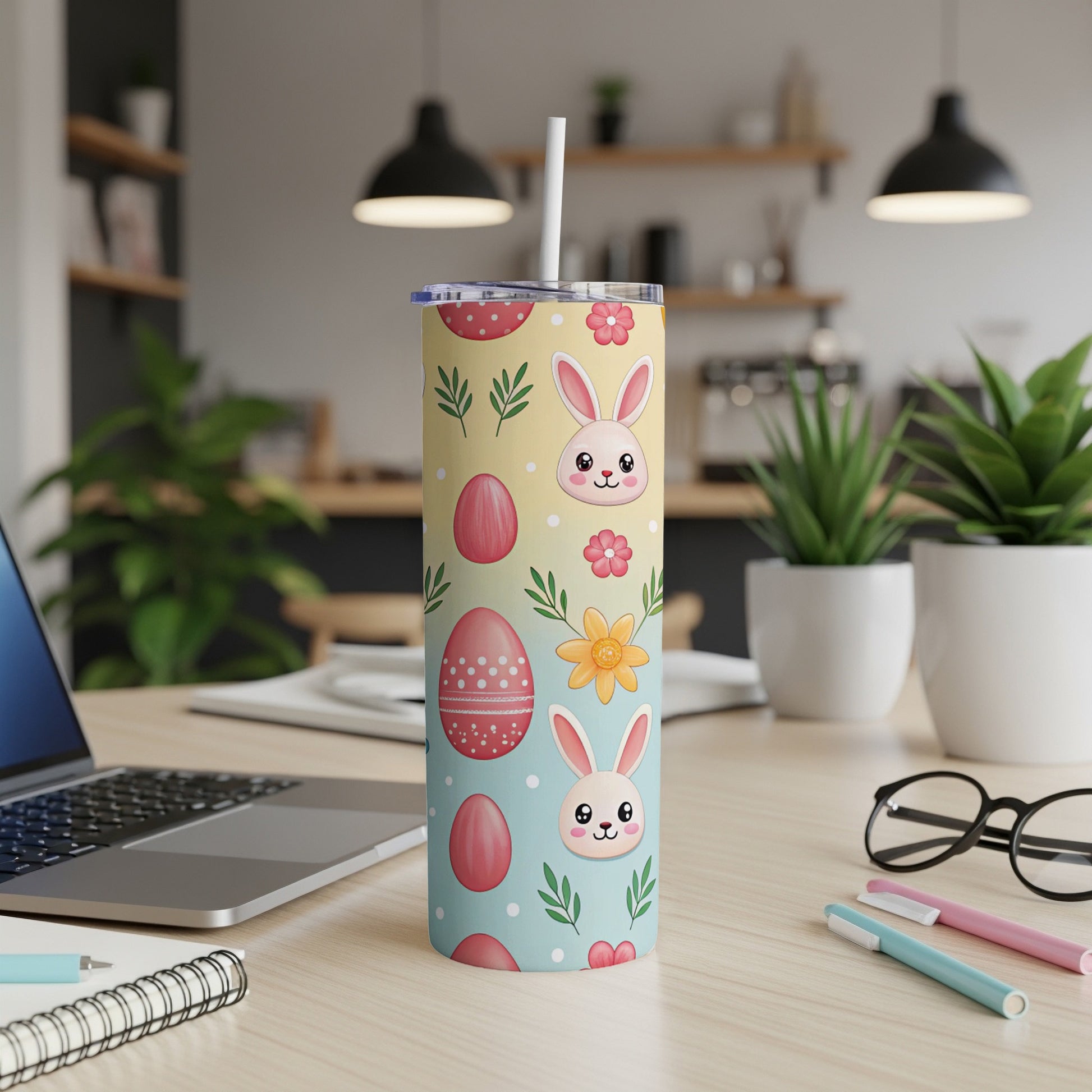 Easter-themed tumbler with bunnies and eggs, on a desk.