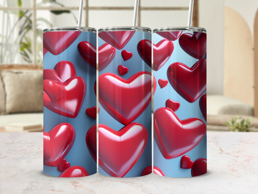 Three tumblers with a red heart pattern on a light blue background.