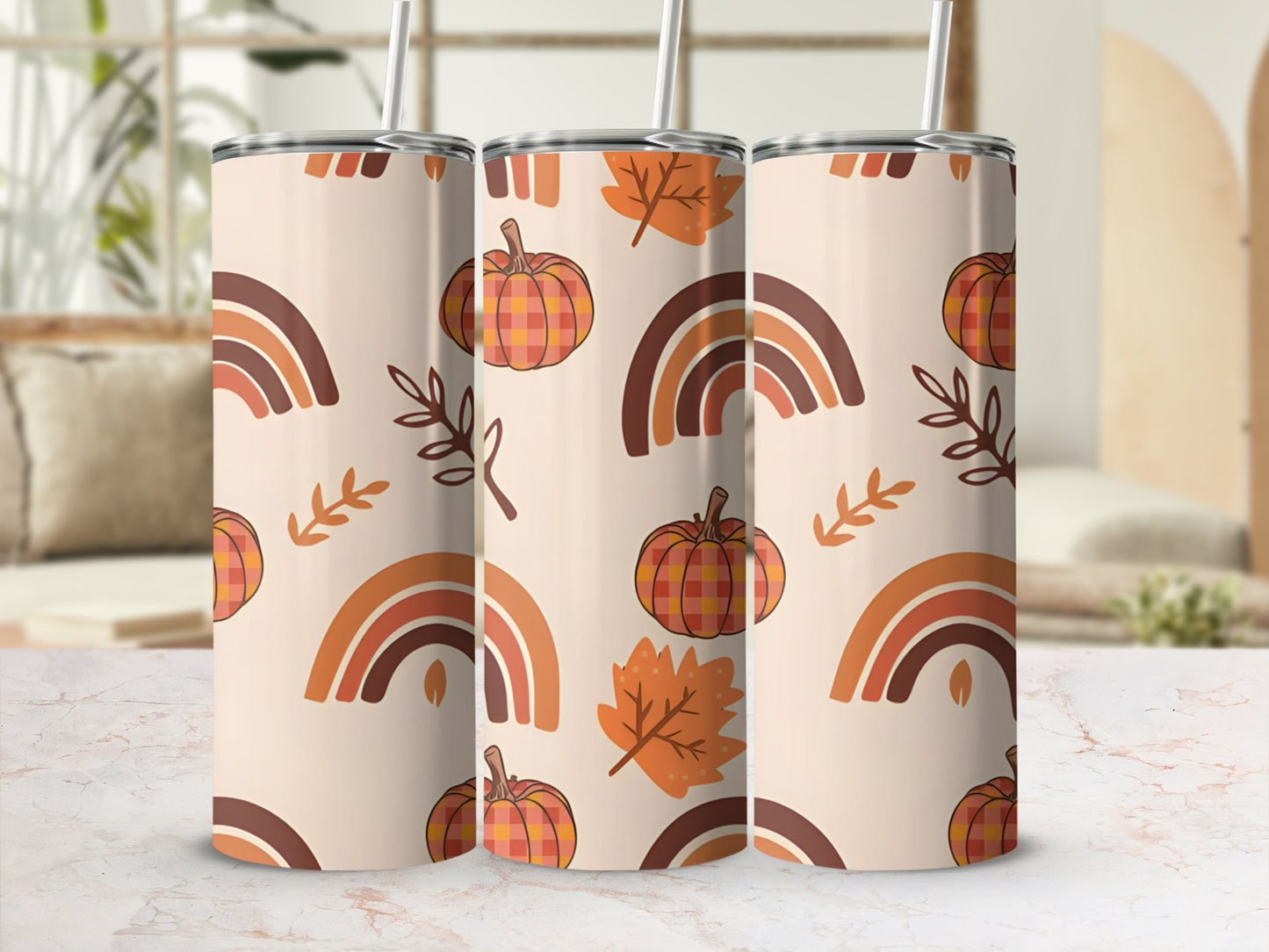 Three tumblers with autumn-themed pattern of pumpkins, leaves, and rainbows.