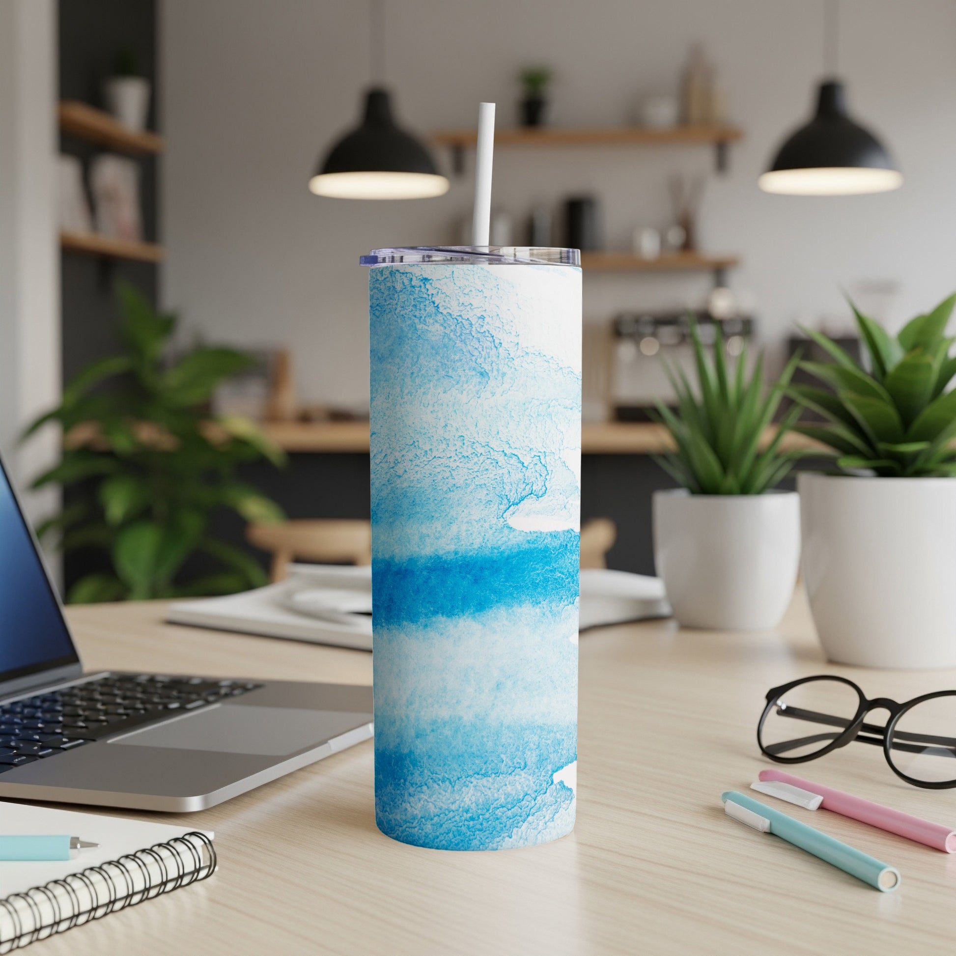 White tumbler with blue watercolor splashes and a straw.