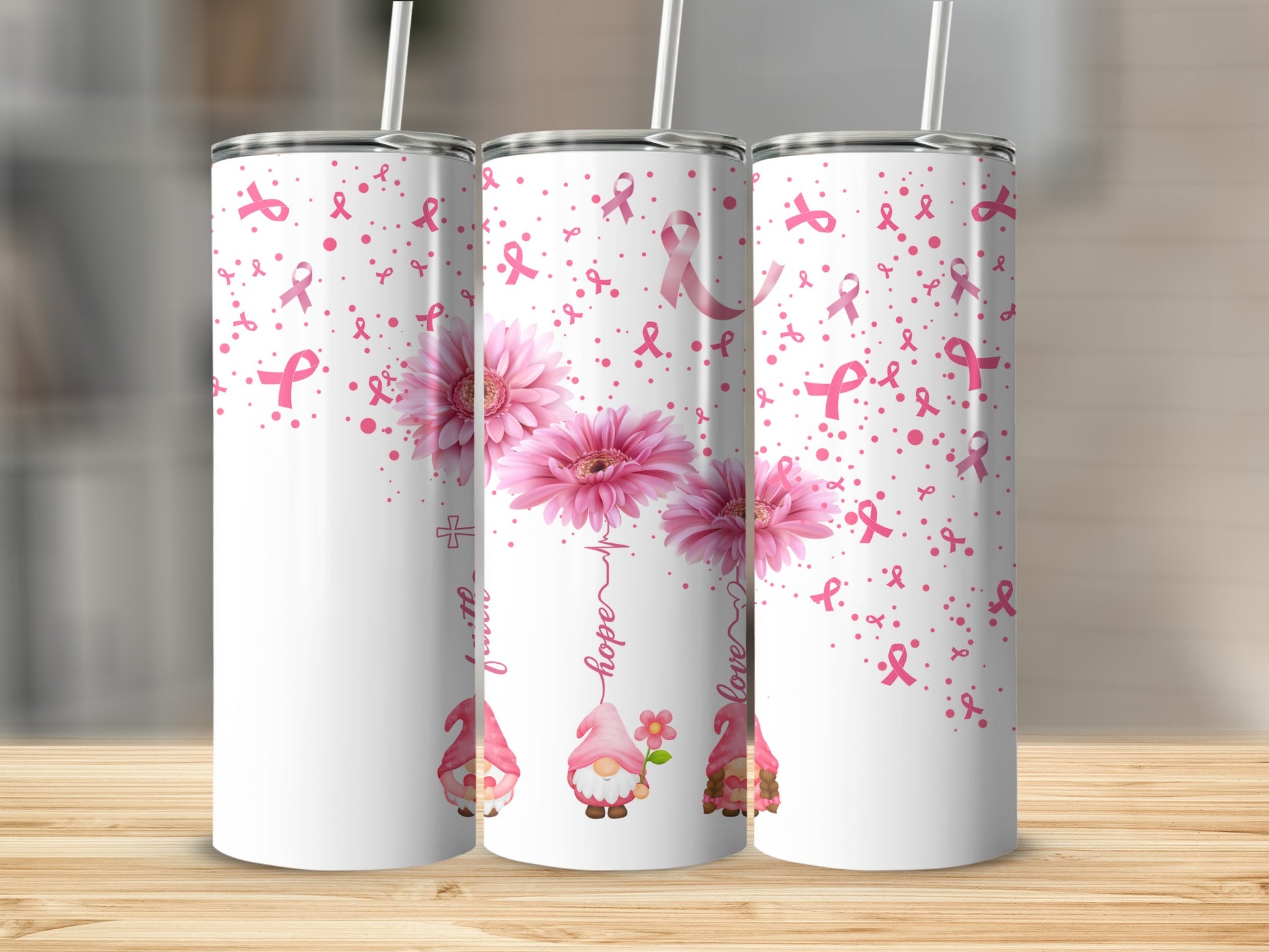 Pink breast cancer awareness ribbon, flowers, and gnomes on three tumblers.