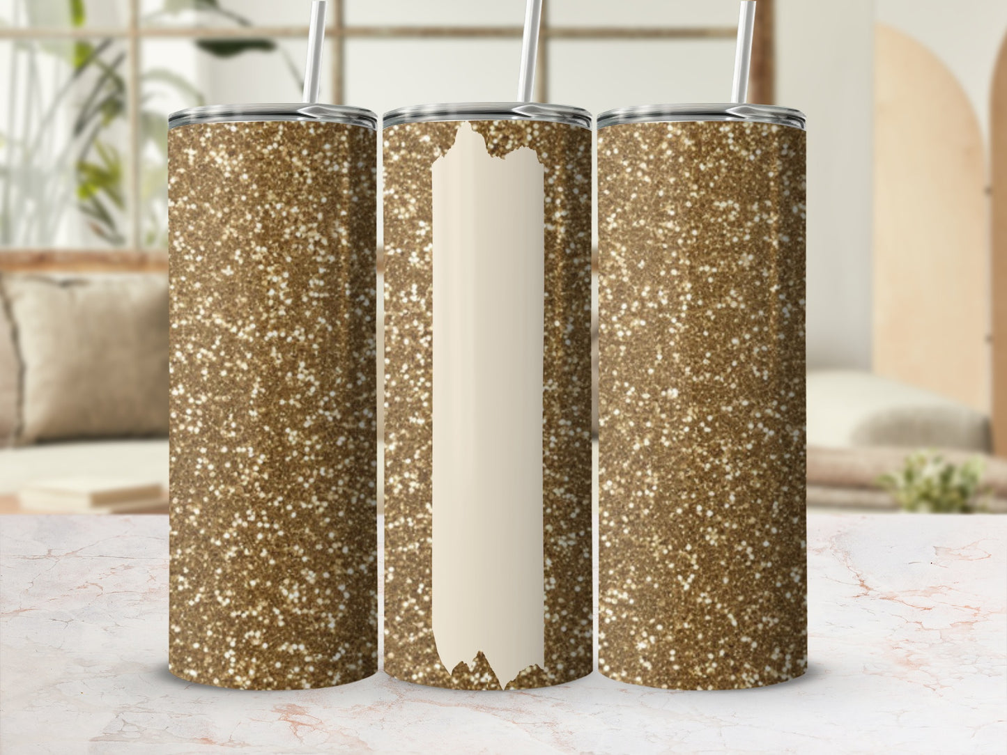 Three glittery gold tumblers with straws on a marble surface.