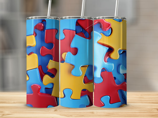 Three colorful puzzle piece tumblers with straws on a wooden surface.