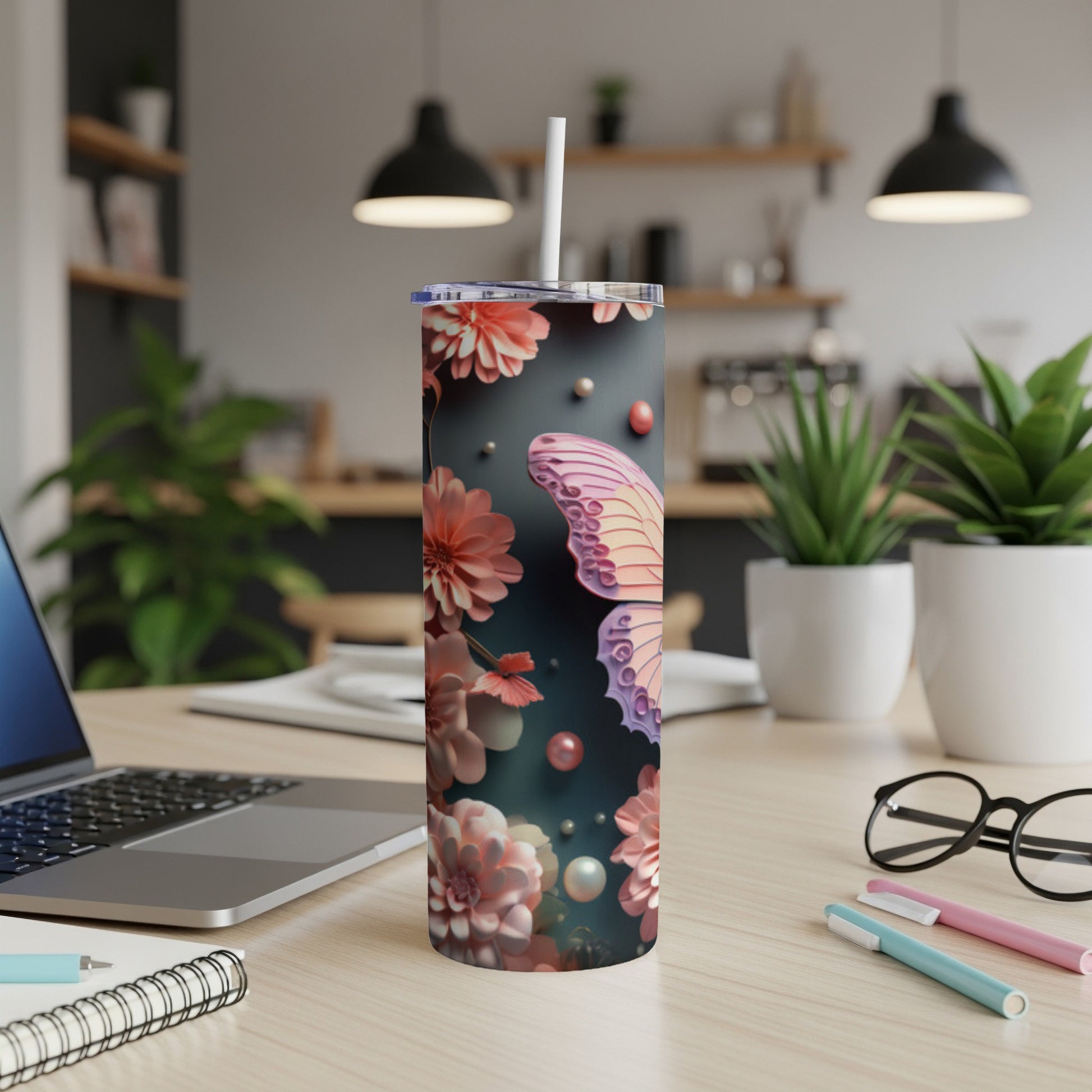 Floral butterfly tumbler with straw on desk with laptop.