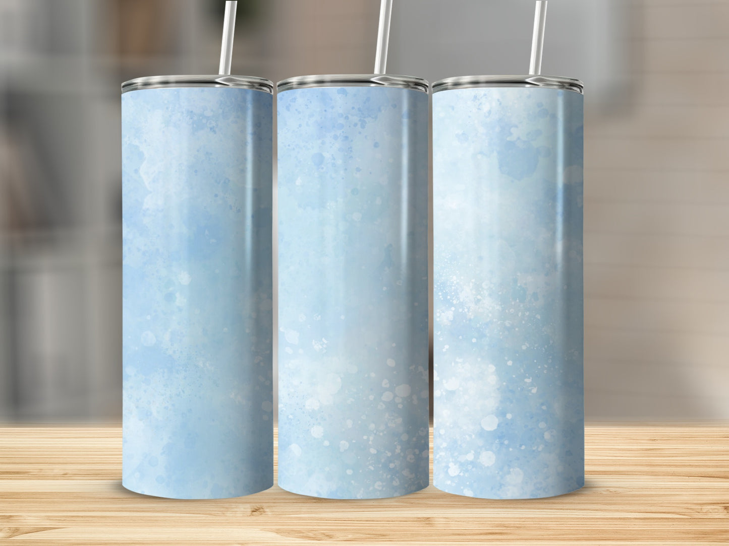 Three tumblers with light blue watercolor splatter design on wooden surface.