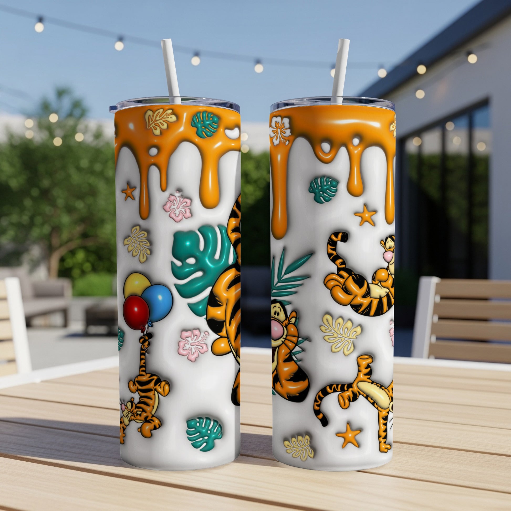 Two Winnie the Pooh Tigger tumblers with tropical leaves and balloons.