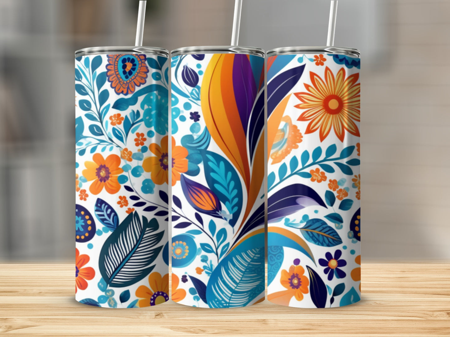 Three tumblers with colorful floral and leaf patterns on a wooden surface.