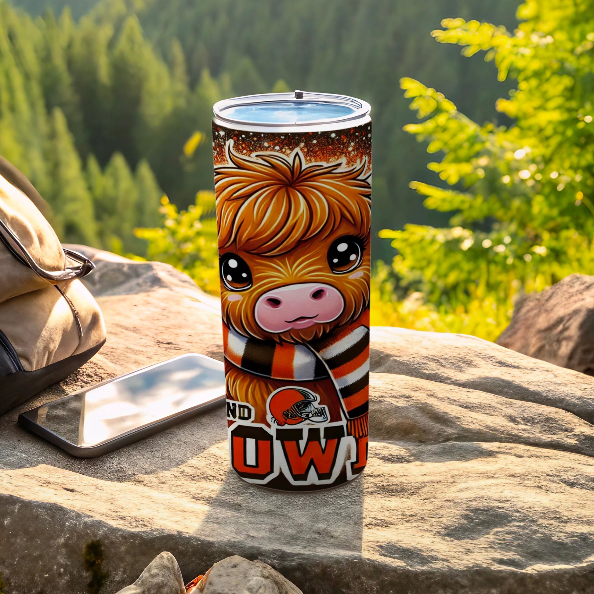 Browns themed Highland cow tumbler with scarf, phone, and backpack.