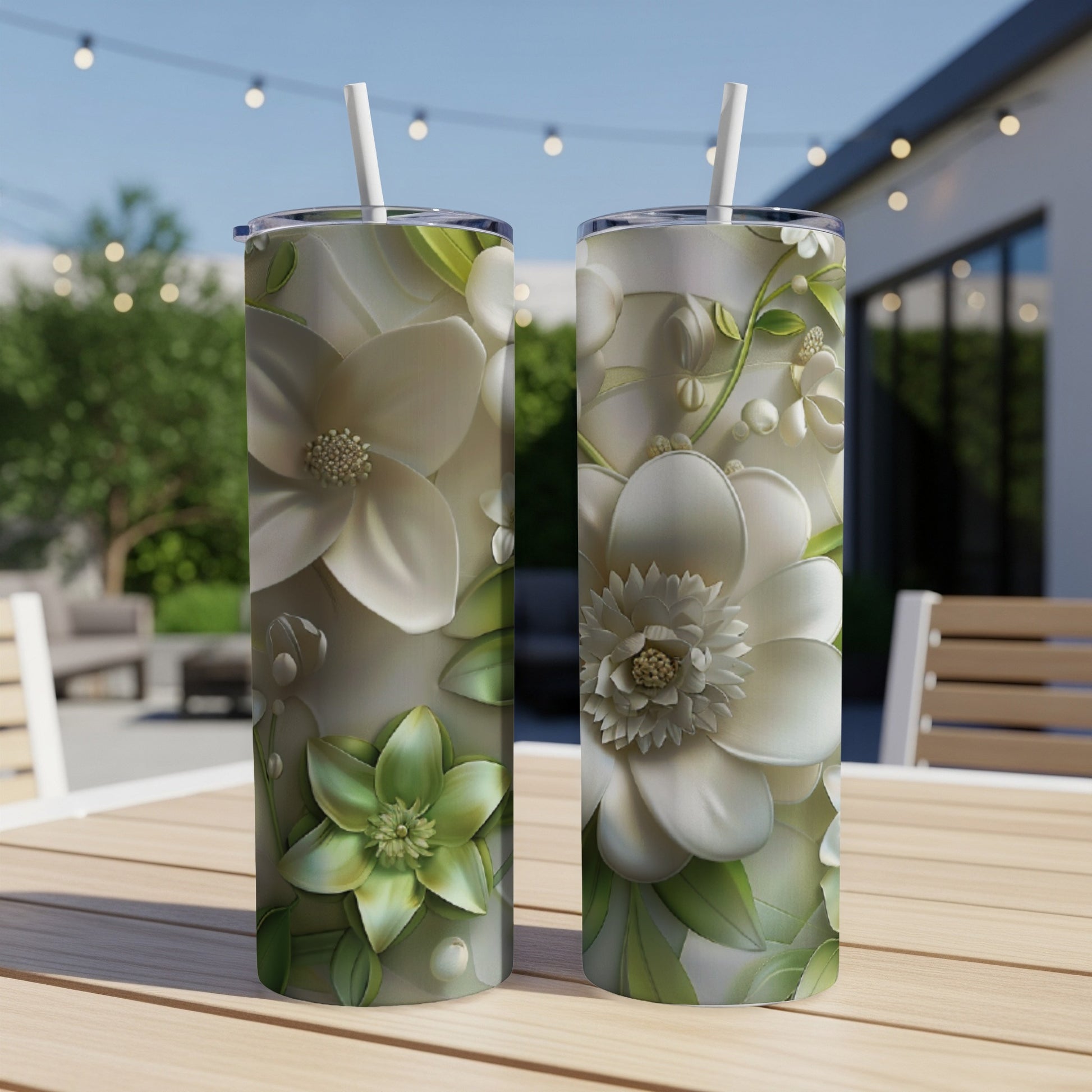 Two white floral pattern tumblers on a table outdoors.