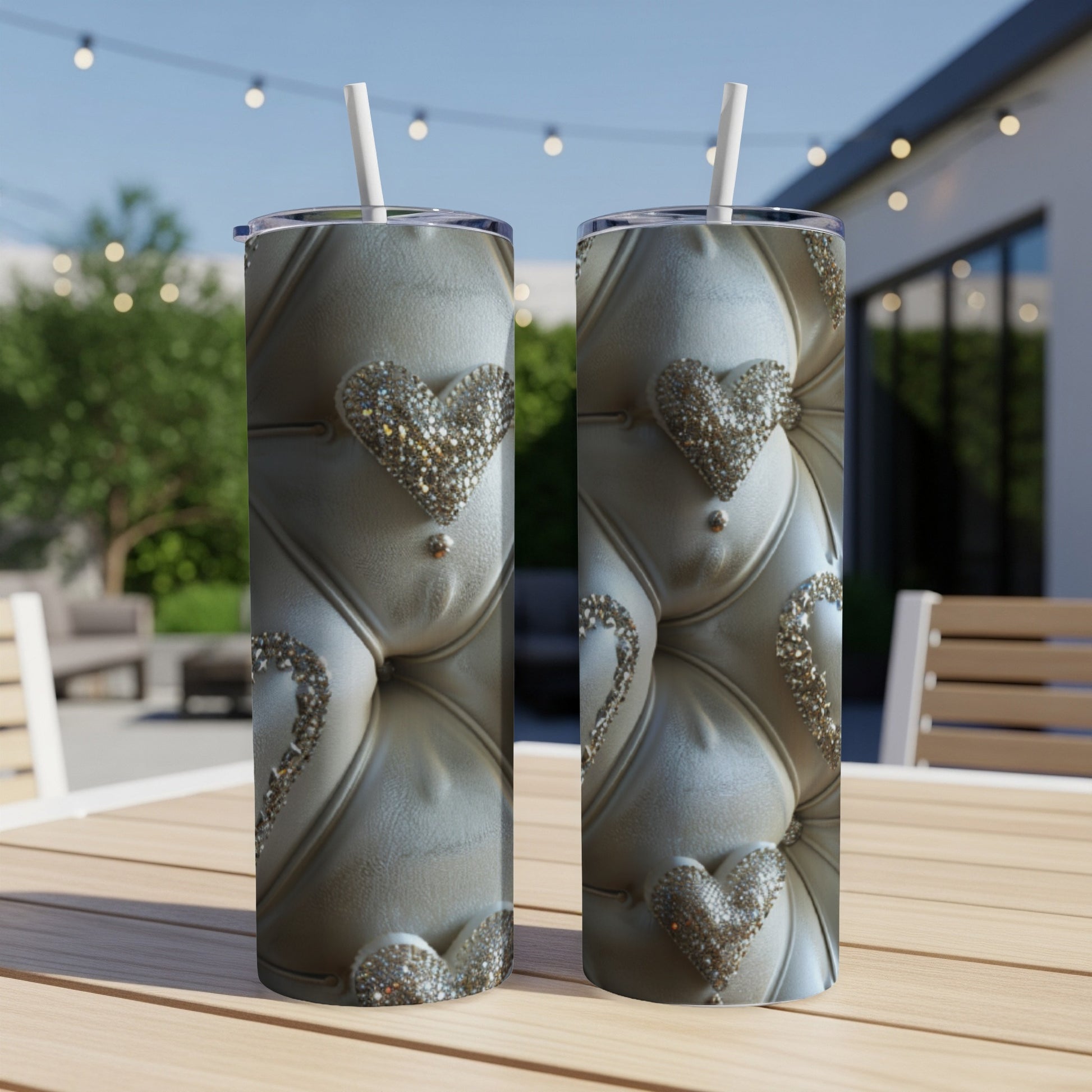 Two ornate tumblers with diamond-encrusted heart designs on a wooden table.