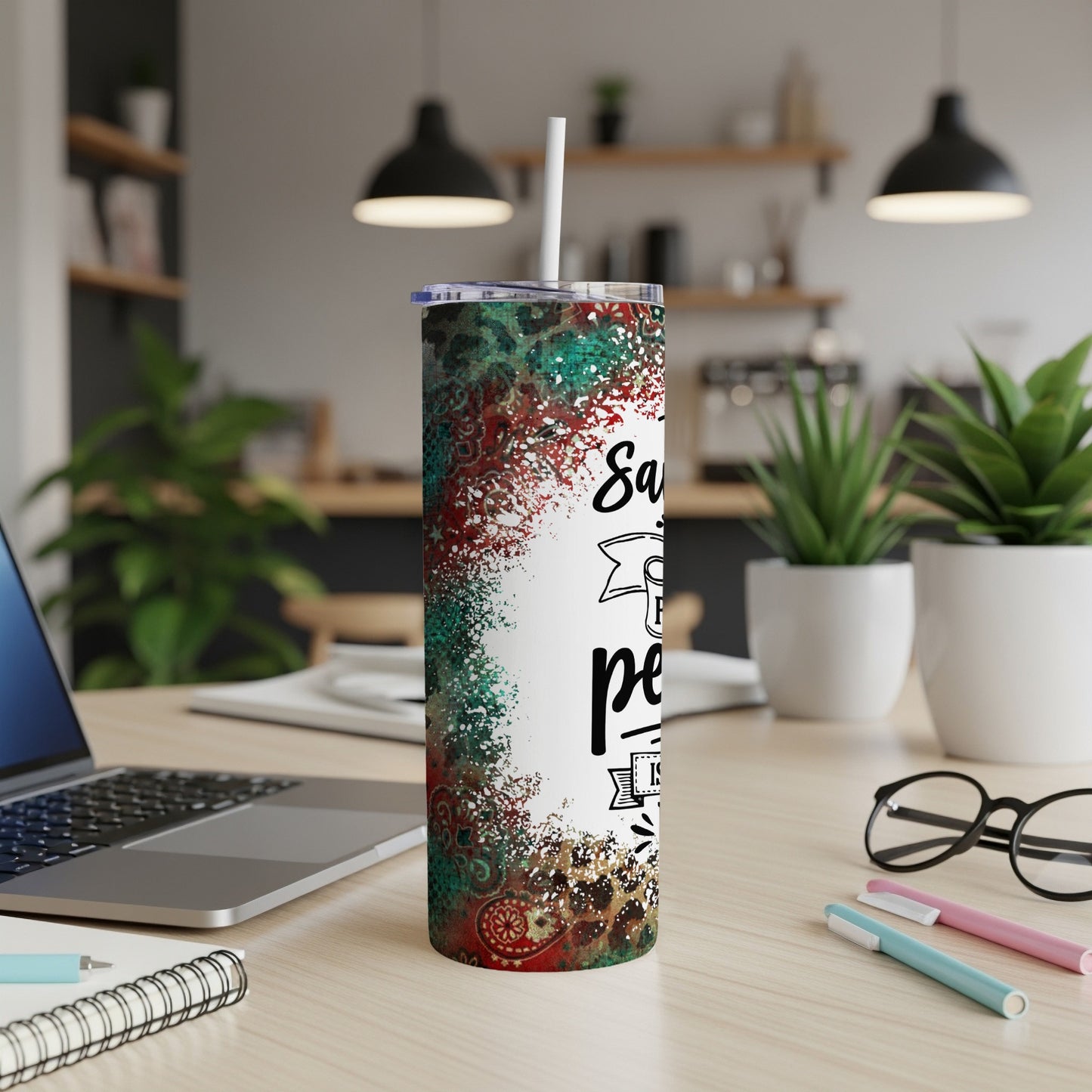 Glittery tumbler with "Santa's favorite" text, on a desk.