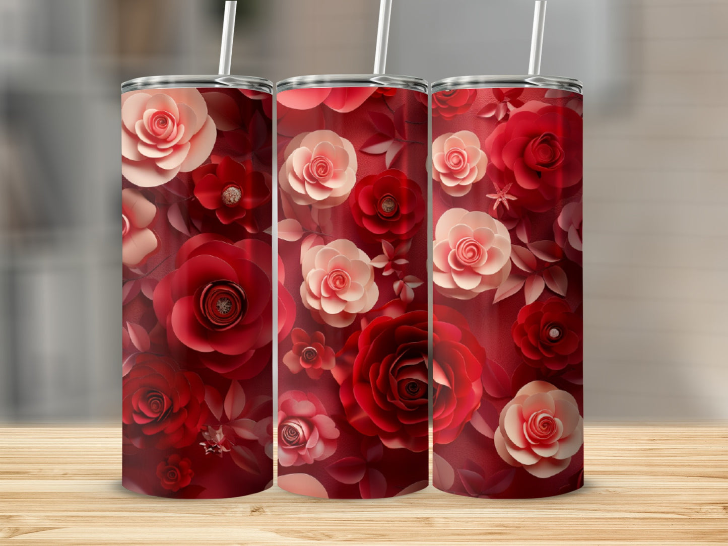 Three tumblers with a red floral design sit on a wooden surface.