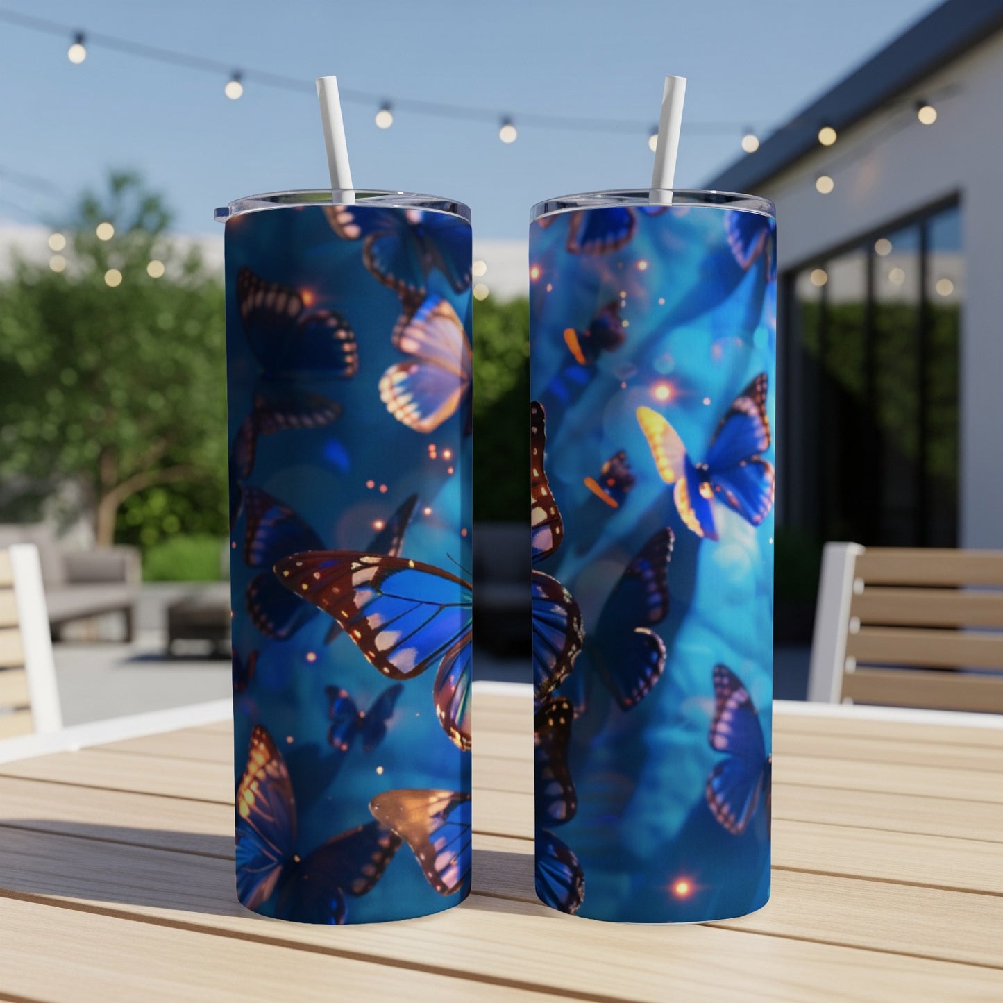 Two blue tumblers with iridescent butterfly designs on a wooden table.