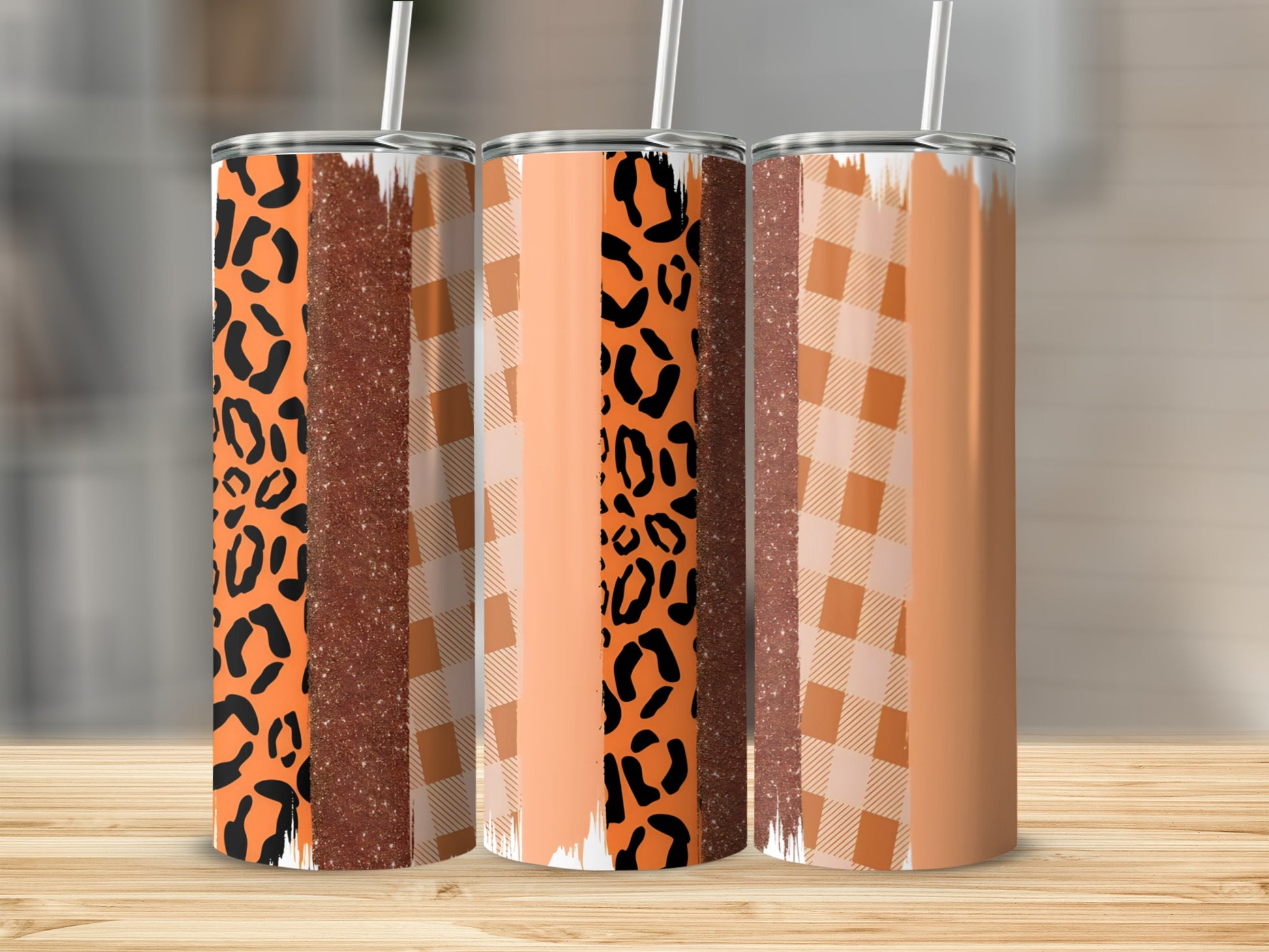 Three tall tumblers with leopard print, glitter, and plaid patterns.