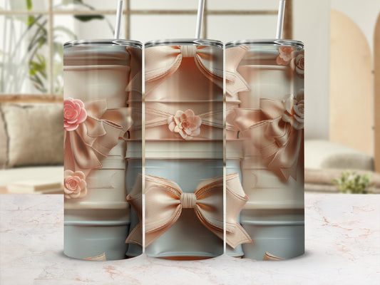 Three pastel tumblers with bow and floral accents, displayed on a marble surface.
