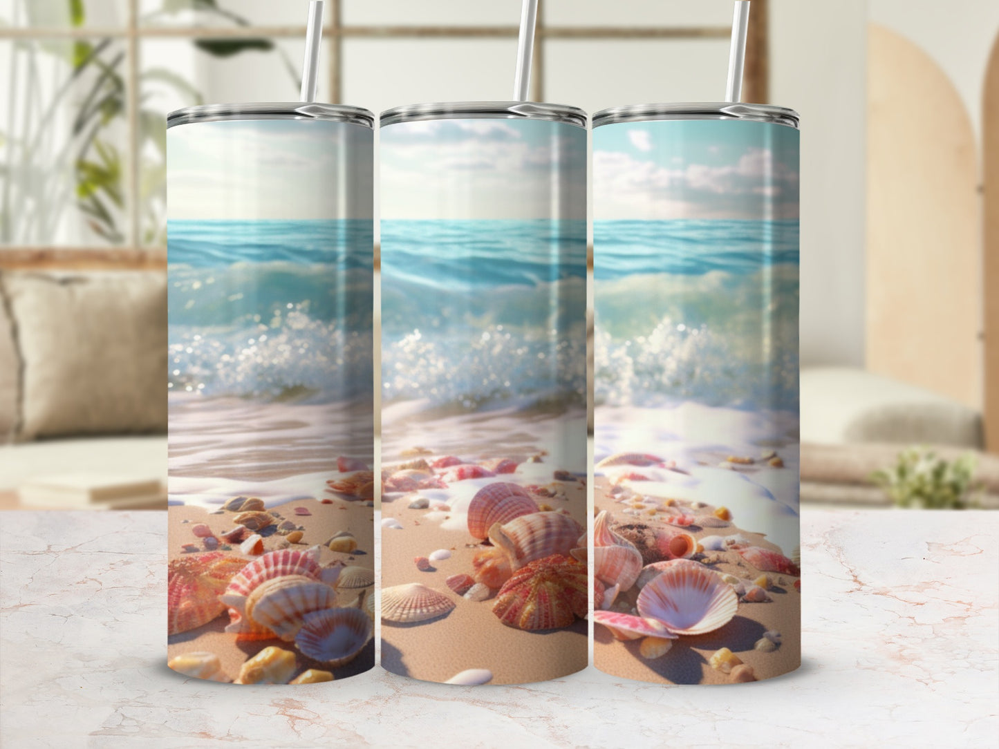 Three stainless steel tumblers with a seashell and beach motif.