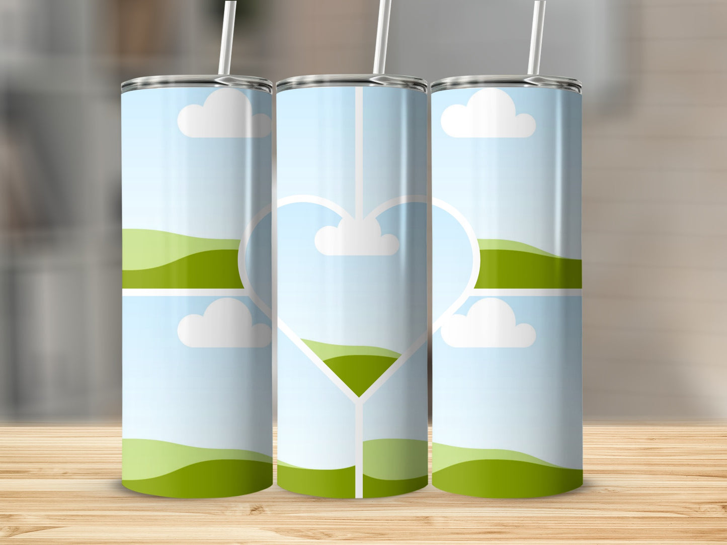 Three tumblers with a landscape design and a heart outline.