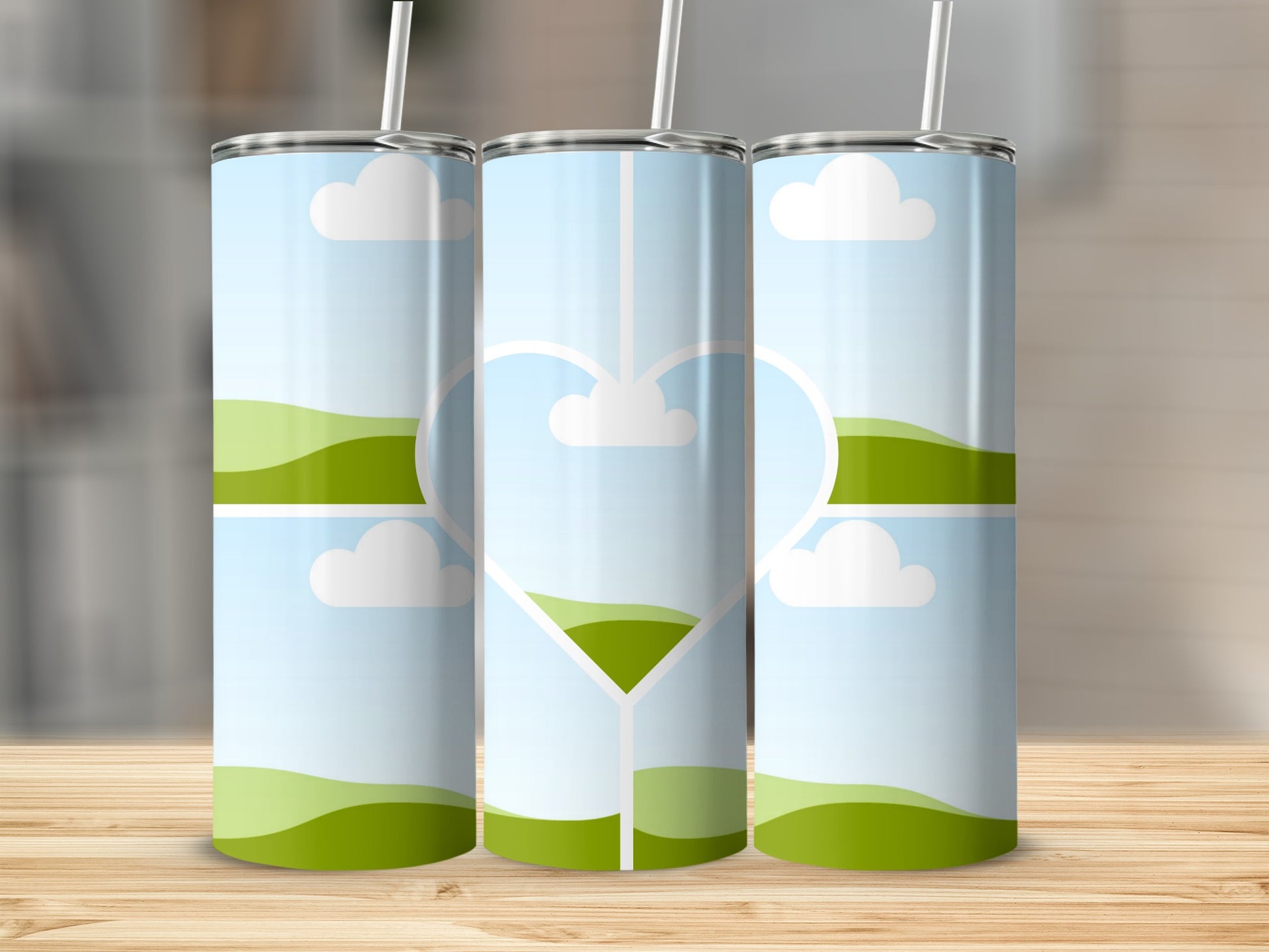 Three tumblers with a landscape design and a heart outline.