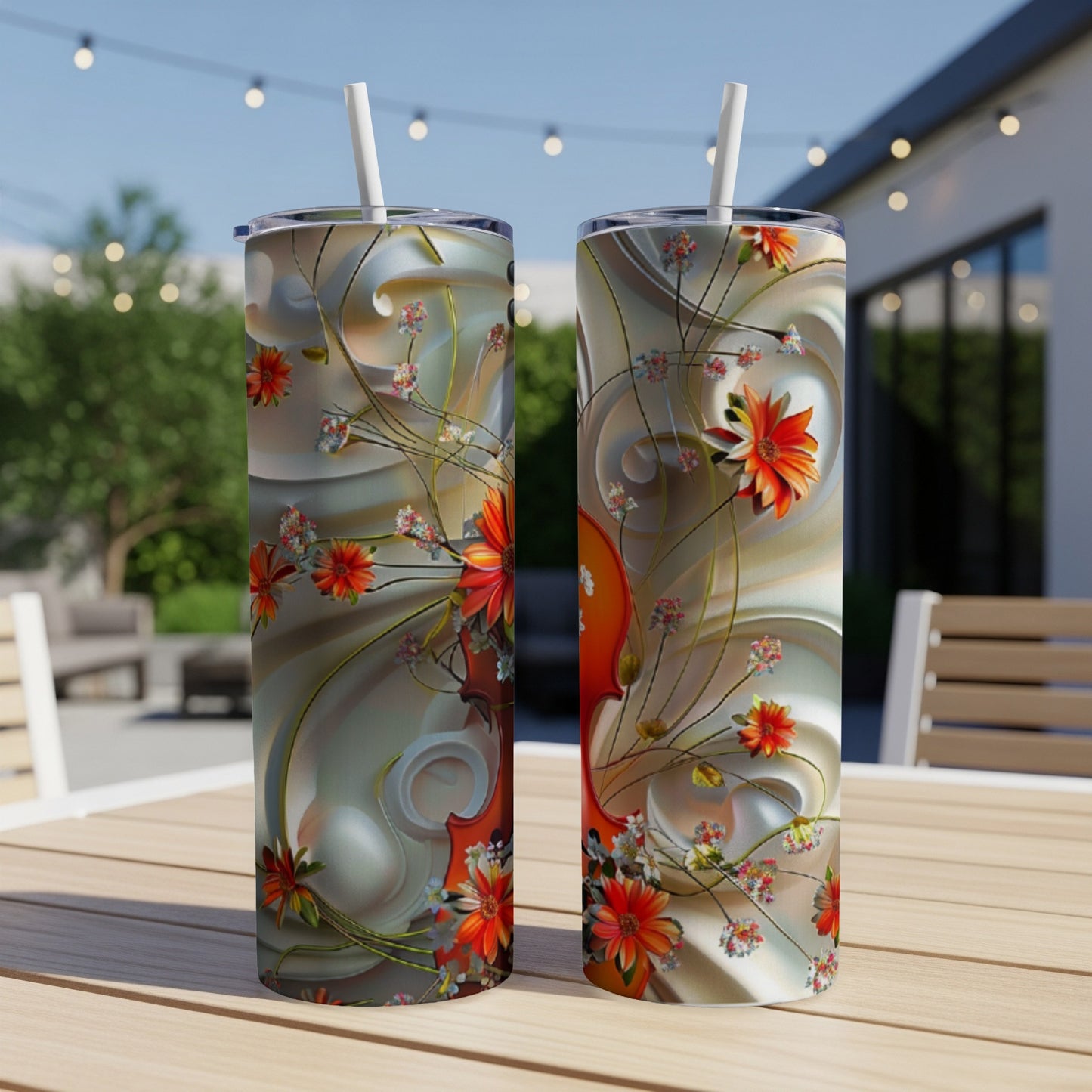 Two tumblers with swirling floral design and orange flowers on a table.