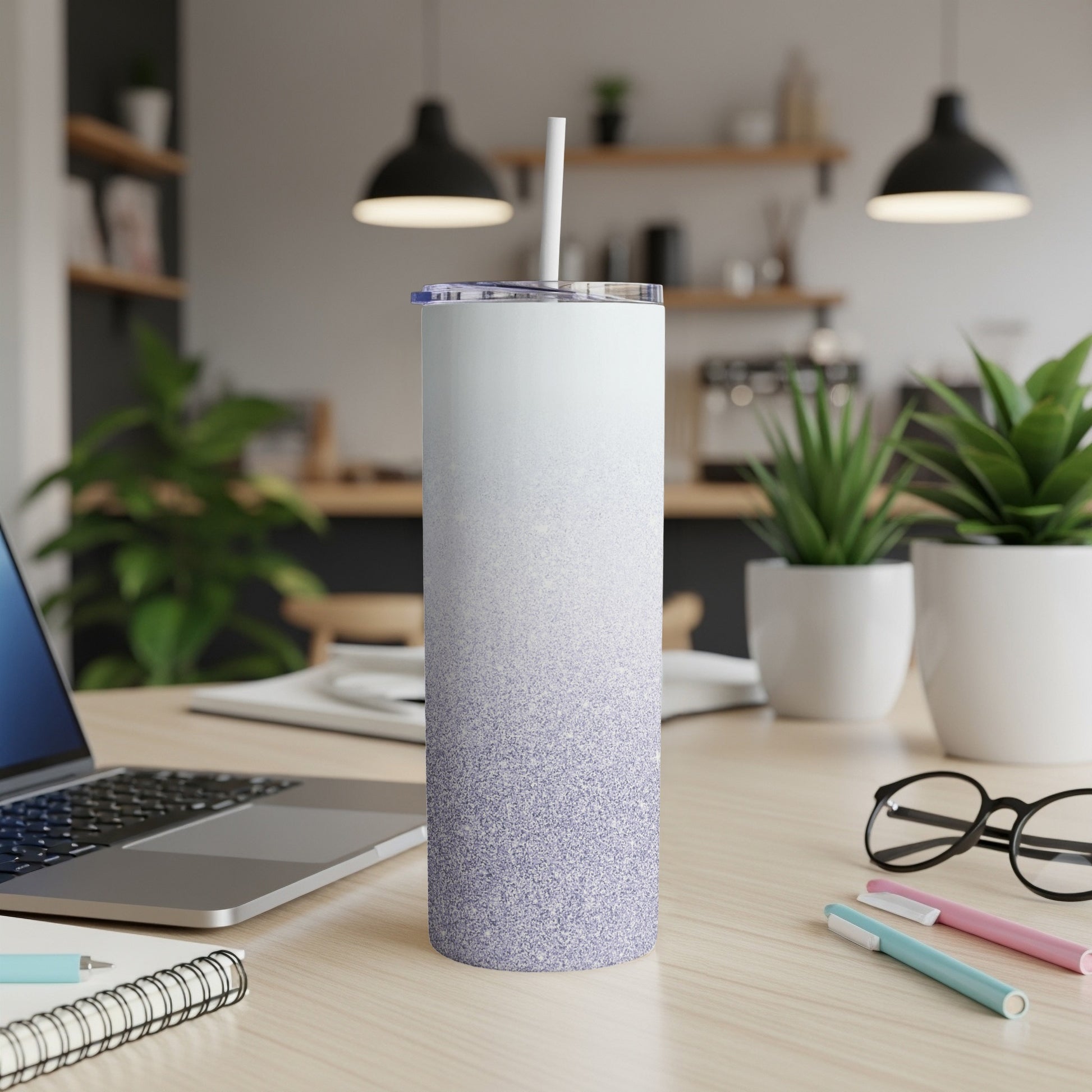White and purple glitter gradient tumbler with straw on a desk.