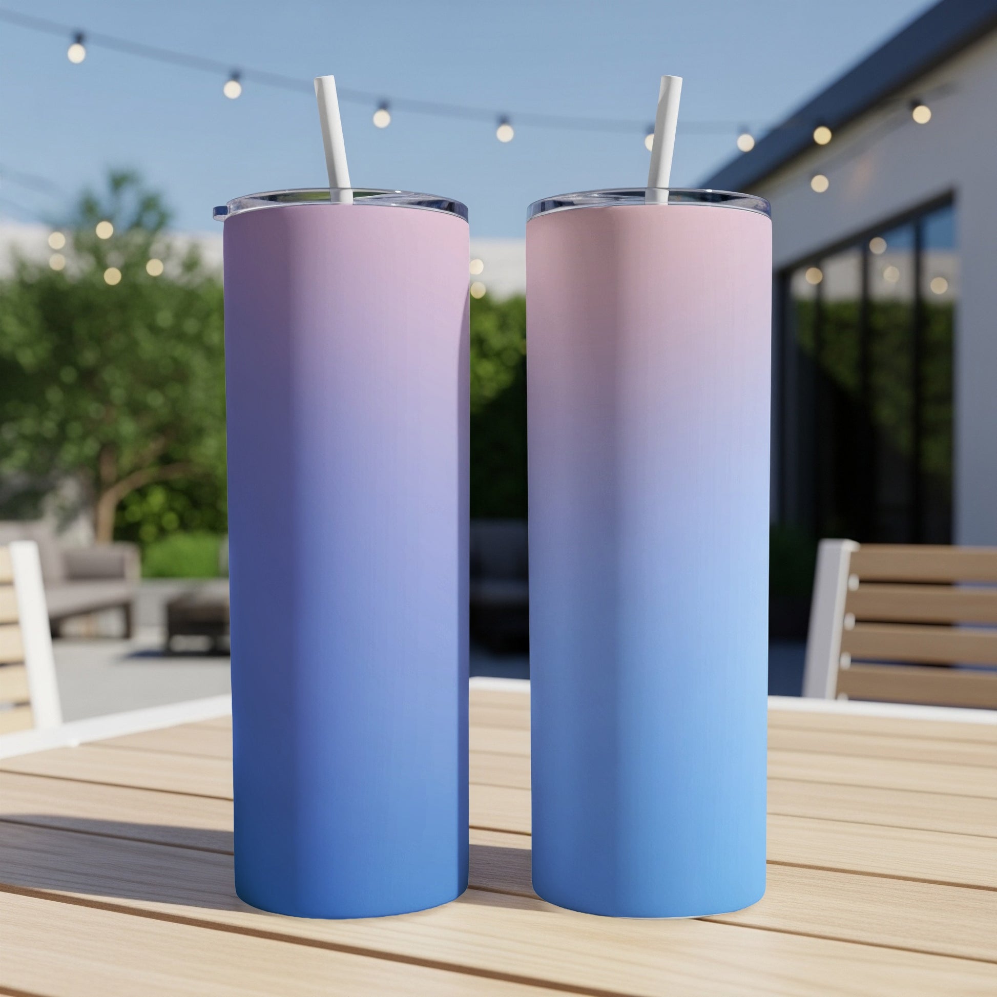 Two tall tumblers with pink and blue ombre gradient, on a wooden table.
