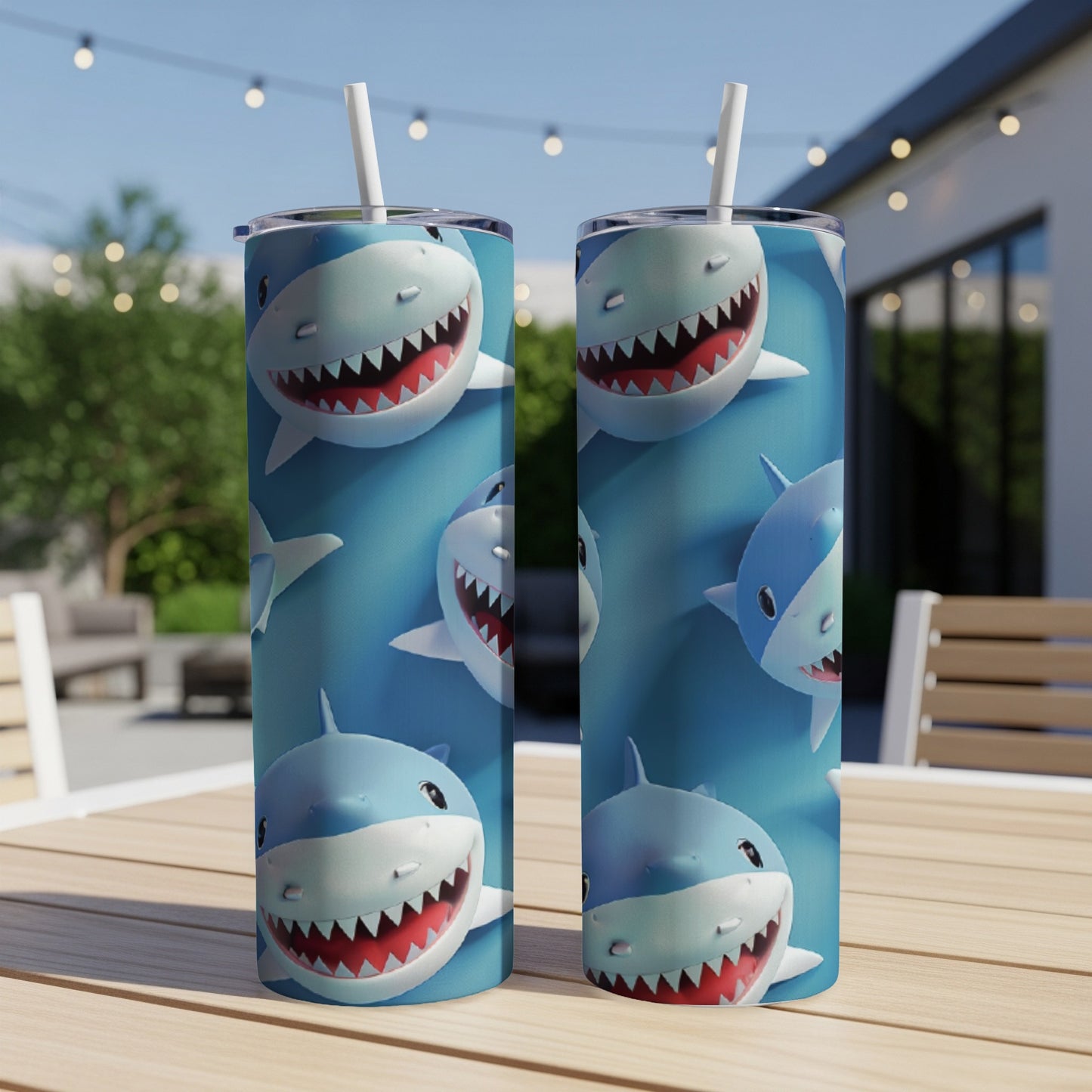 Two tumblers with smiling cartoon shark pattern on a wooden table.