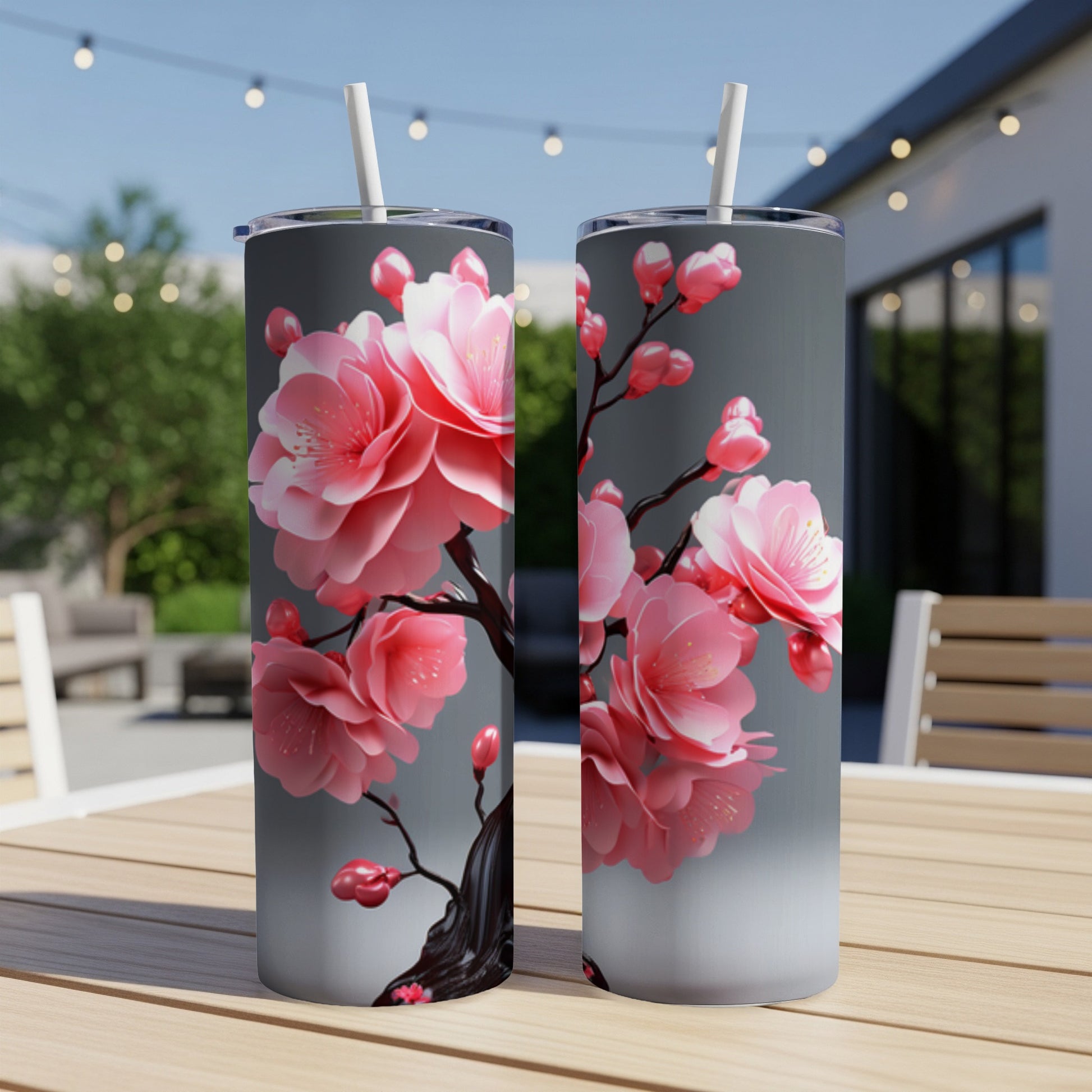 Two tumblers with pink cherry blossoms on a gray background.
