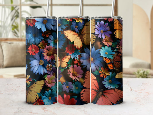 Three tumblers with colorful flowers and butterflies against a blurred background.