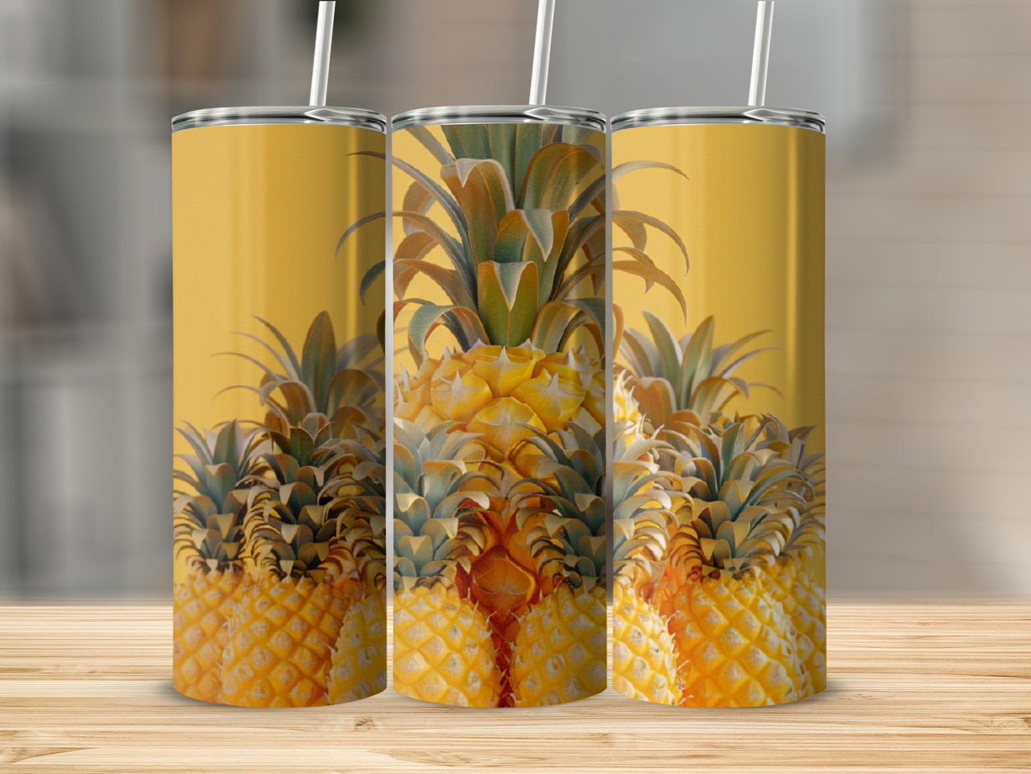 Three tumblers with a pineapple pattern sit on a wooden surface.