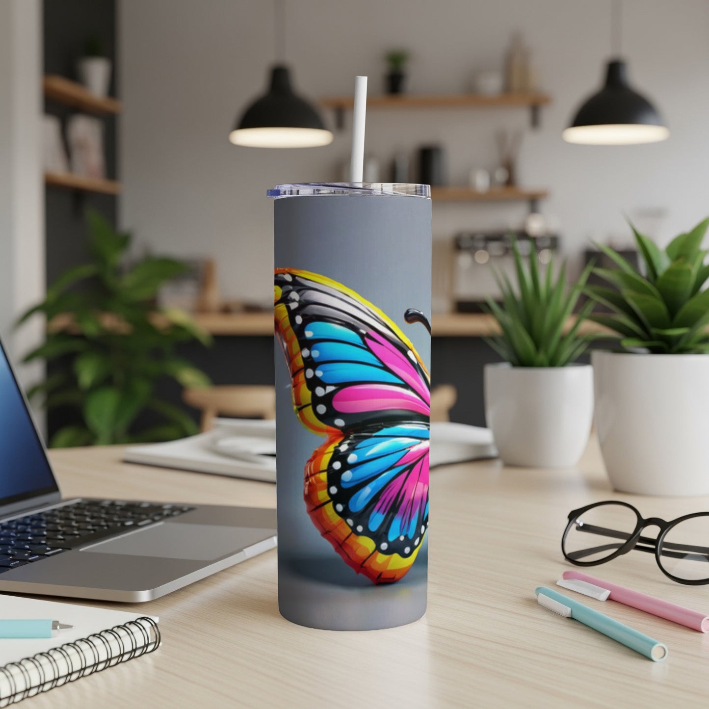 Tall, insulated tumbler with vibrant butterfly wing design and straw.