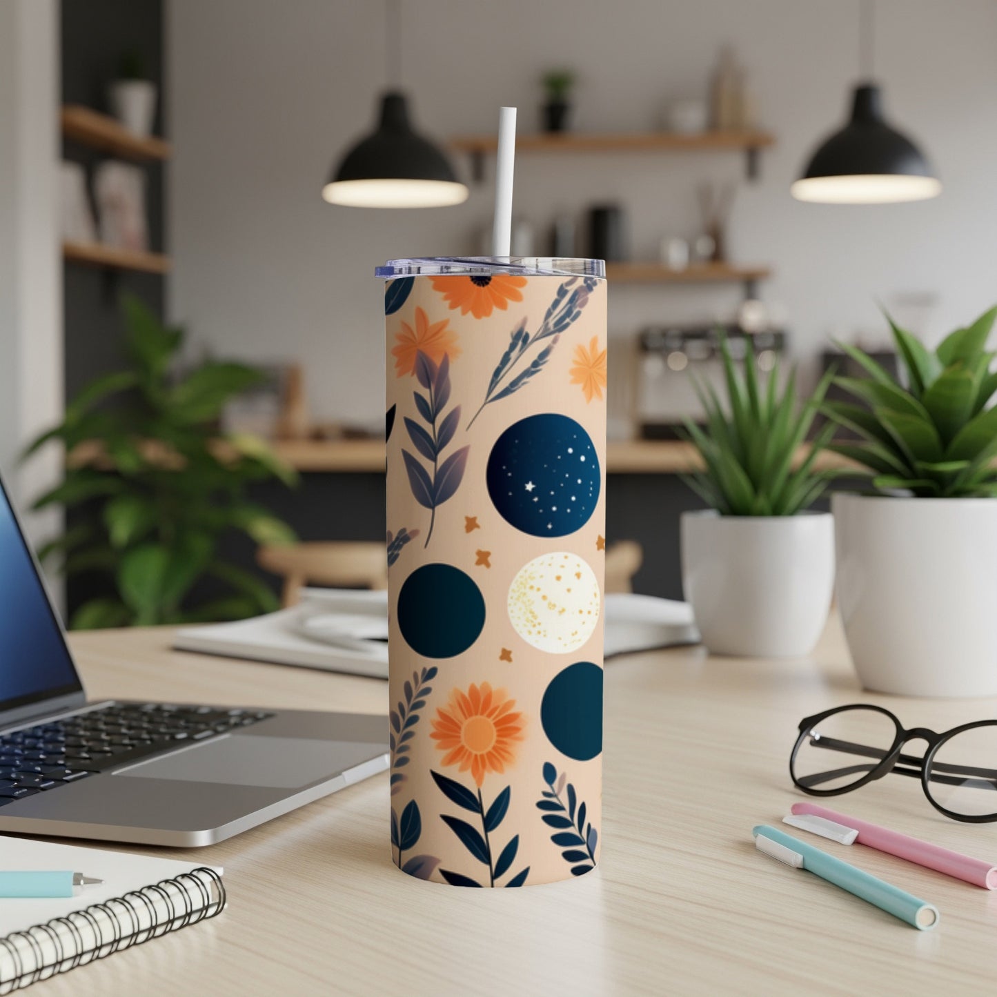 Tall insulated tumbler with celestial and floral pattern on beige background.