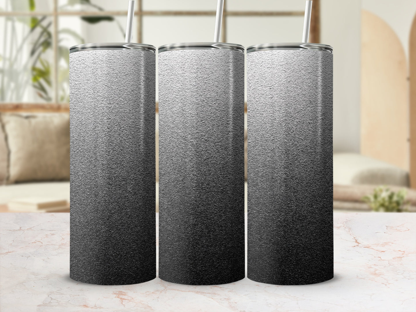 Three silver and black gradient tumblers with straws, displayed on a marble surface.