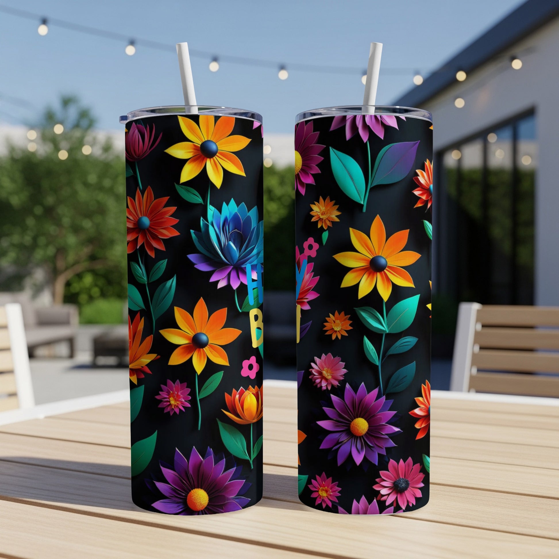 Two tumblers with colorful floral designs on a table.