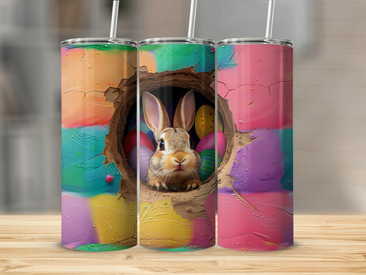 Bunny peeking from hole surrounded by colorful Easter eggs on a tumbler.