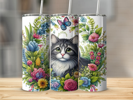 Gray and white cat surrounded by colorful flowers and greenery.