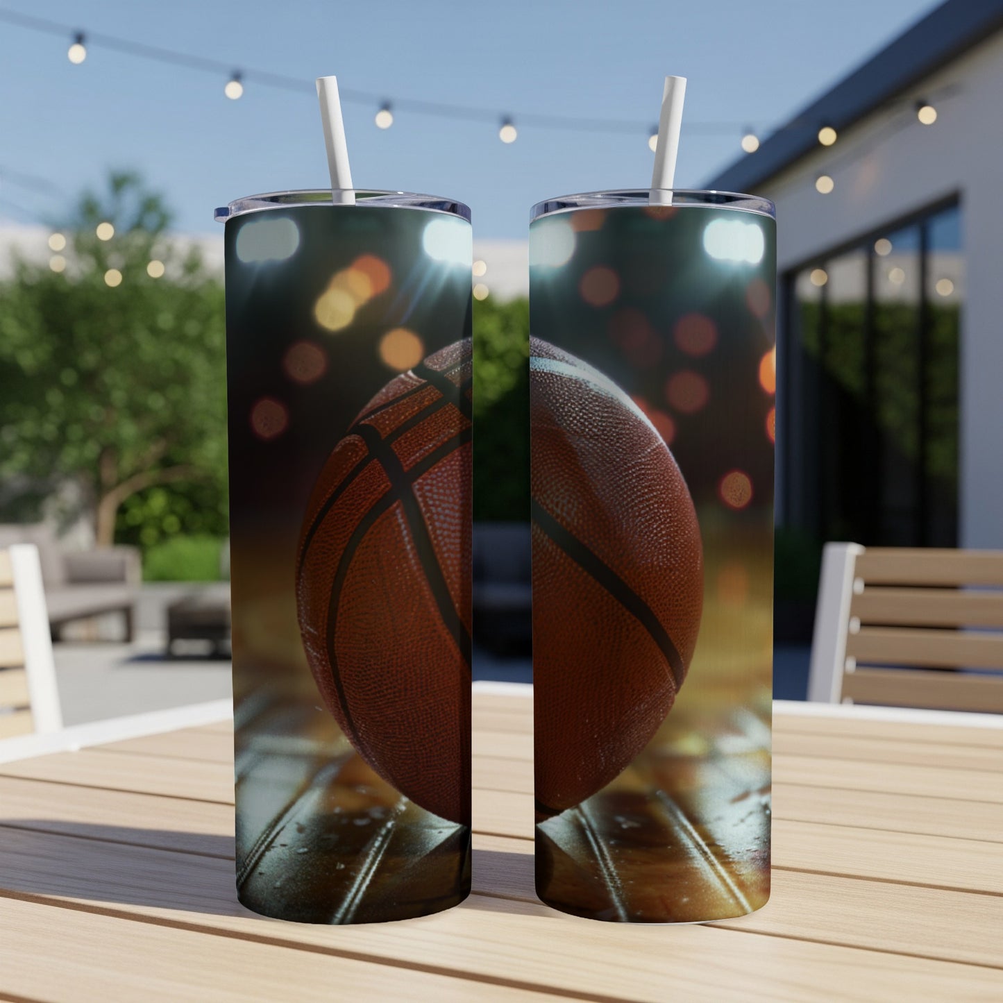 Two basketball tumblers with straw, outdoors on a wooden table.