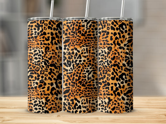 Three tumblers with leopard print patterns on a wooden surface.