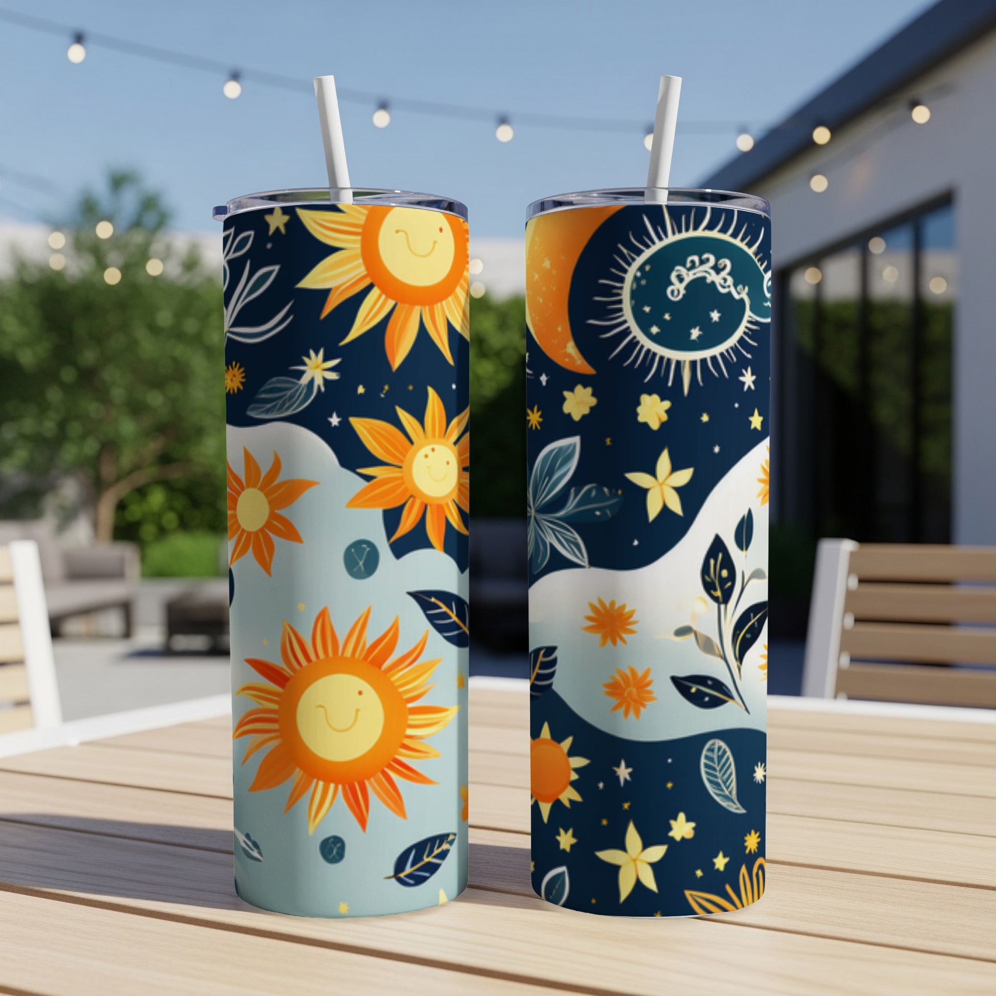 Two tumblers with sun, moon, and floral designs on an outdoor table.