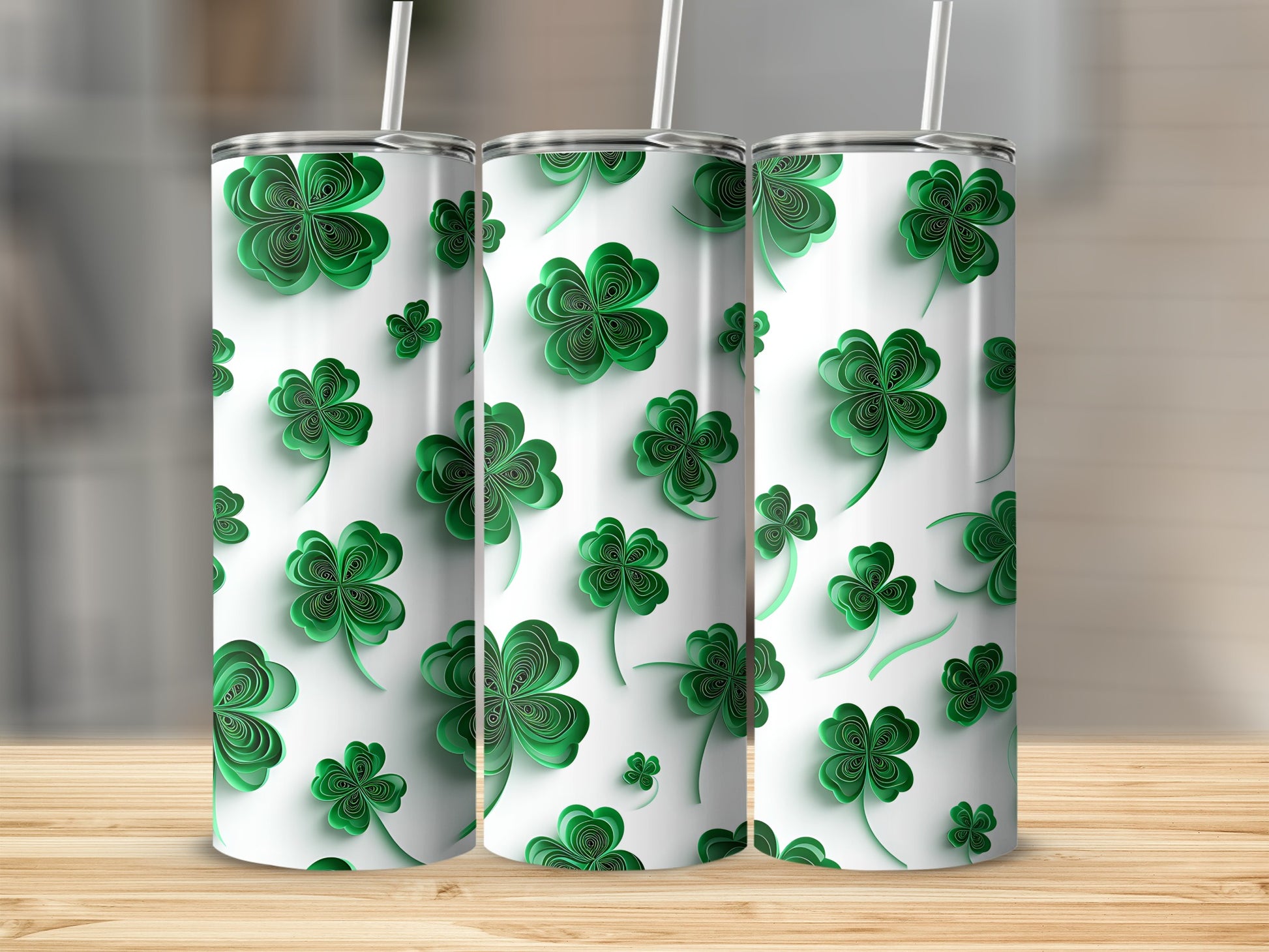 Three tumblers with a repeating green shamrock pattern and white straws.
