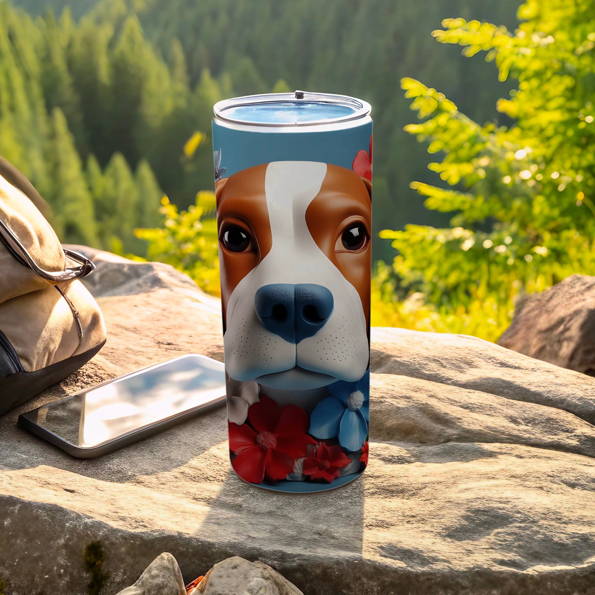 Dog face with flowers on a blue tumbler next to phone and bag.